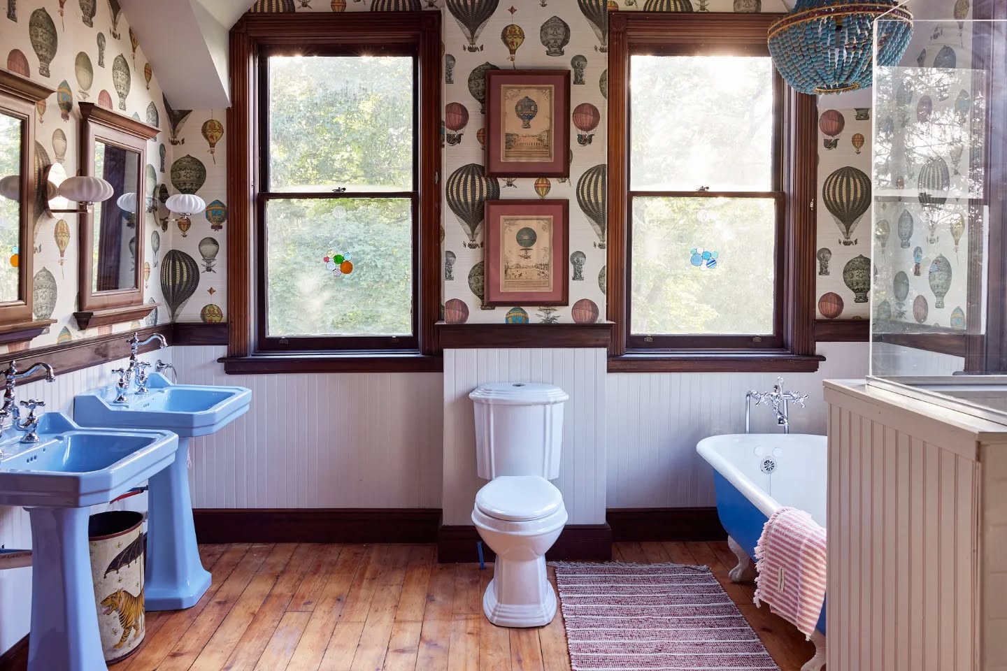 One of my favorite bathrooms of all time - a throw back to WACOH where we transformed a guest bedroom into a spacious kids bathroom with the most delightful Victorian Hot air balloon wallpaper. Adding a bathroom to a new space is no small task and is mostly contingent on preexisting plumbing conditions. This room shared a wall with another bathroom and sat above the kitchen, so was well positioned for new piping! We kept the original hardwood floors (duh), added wainscotting and a thick chair rail (that @savingoldhouses belabored over for hours), stained to match the window frames perfectly. ✨ A brand new shower stall was built and voila!
The real heroes of the room? Twin pedestal sinks from @theboldbathroomcompany and the refurbished claw foot tub from @architectural_parts_warehouse - both in POPs of blue that reference small details in the @spoonflower wallpaper. The whimsy! The charm! Designed for kids, sure - but who wouldn't love to take a bubble bath in here!? This is my idea of an escape room.
💙🩵💦🛁🎈
Photography @smunguia 📸
#bathroomdesign
#oldhouselove
#vintageeverything
#victorian