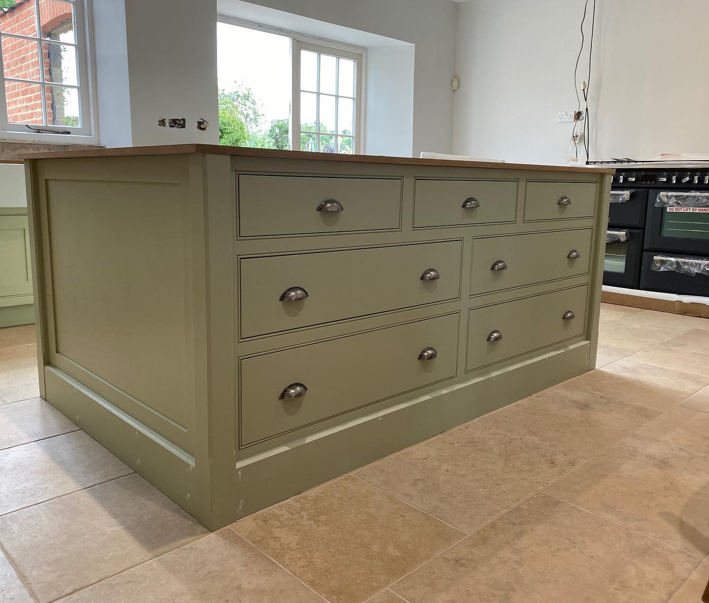 Looking at this beautiful island in its final stages awaiting its last coat of paint and the granite worktop got us thinking when did it become so popular to have a large centre island? Islands came into fashion around the 1980's when design concepts started changing from stuffy, cramped kitchens, to more open and efficient spaces. Over time, kitchens were no longer hidden away, and instead became areas for people to socialise and spend time with one another. Whether you have seating around the whole island or just one side, it creates a place to prepare, cook, eat and socialise. How nice to invite your friends over to socialise but also keep an eye on the food at the same time! #handmade #bespoke #kitchens #island #centreisland #littlegreenpaintcompany