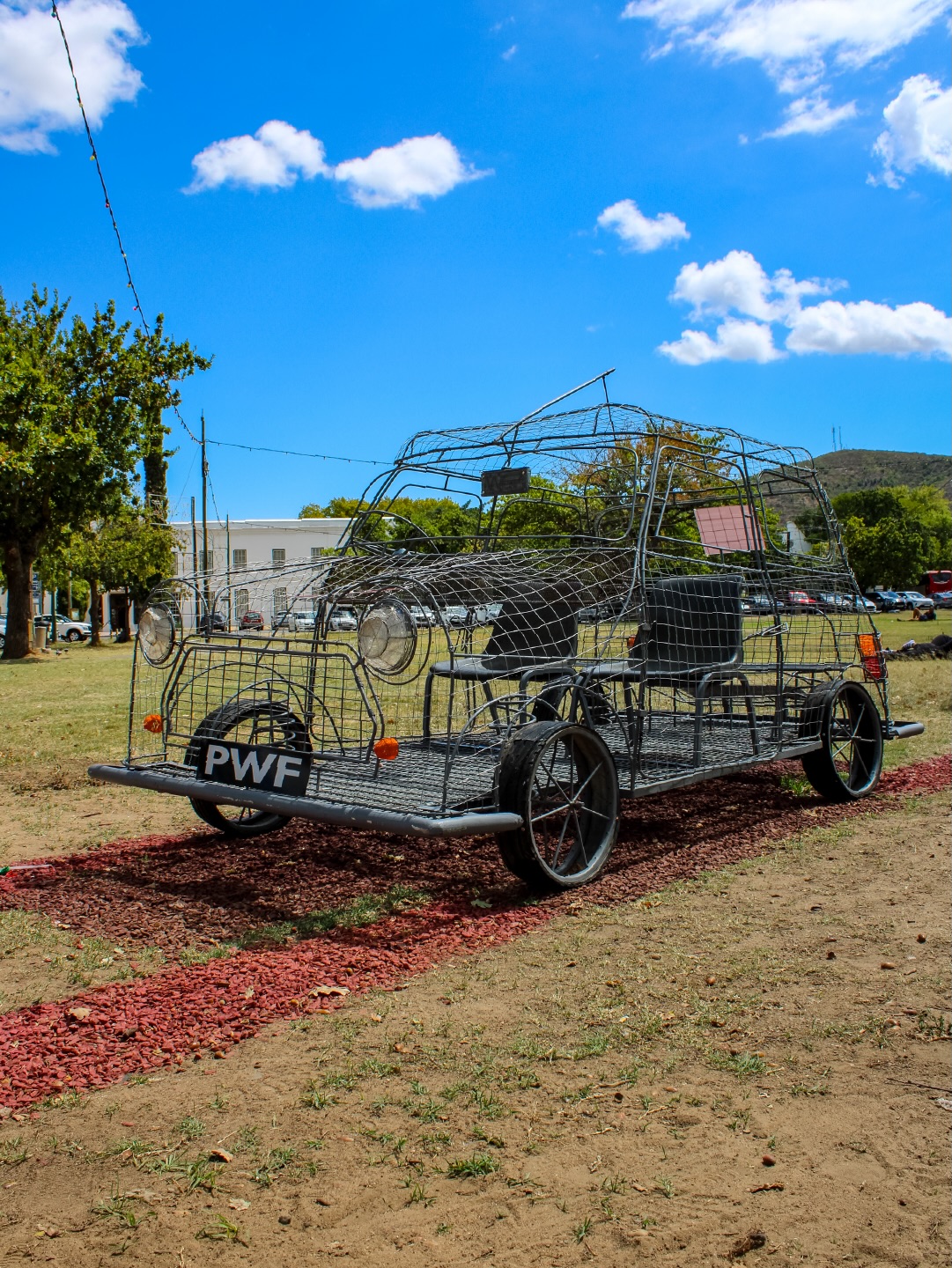 DRAADKAR by Philipstown Wirecar - @philipstownwirecar
2026 | Wire, beadwork | Corner of Mill Street & Blom Road (Die Braak)
Specially commissioned for this dreamscape public art exhibition, this life-size wire car model of a 1970s Mini Cooper was made over a period of 2 months by young artists at the Philipstown WireCar Foundation. Philipstown, a remote town in Karoo town in South Africa, is a place wired with tradition, passion and creativity. Once a year, the town erupts with excitement as kids push the wire cars they have built around the streets in the WireCar grand prix on a 3km track. A wire car (or draakar, as locals call it) is a DIY toy built from scrap wire, soda cans, bottle caps and a lot of ingenuity. Every year, the kids of Philipstown test their creativity and skill by pushing these cars to their limits. We invite visitors, both young and old, to interact with the car — get in the driver seat, stand with your head out of the sunroof — and remember what it feels like to be young and free, on the open road to your dreams…
Learn more → www.sost.co.za/artwork/draadkar
Dreamscapes - Form and space through curious eyes curated by Dr Mike Mavura @mikemavura_ | 26 February 2026 – 30 January 2027
Presented by the Stellenbosch Outdoor Sculpture Trust, @visitstellenboschnow, and proud patron, Private Clients by Old Mutual.
#SOST #Dreamscapes #Stellenbosch #PhilipstownWirecar #WealthCurated