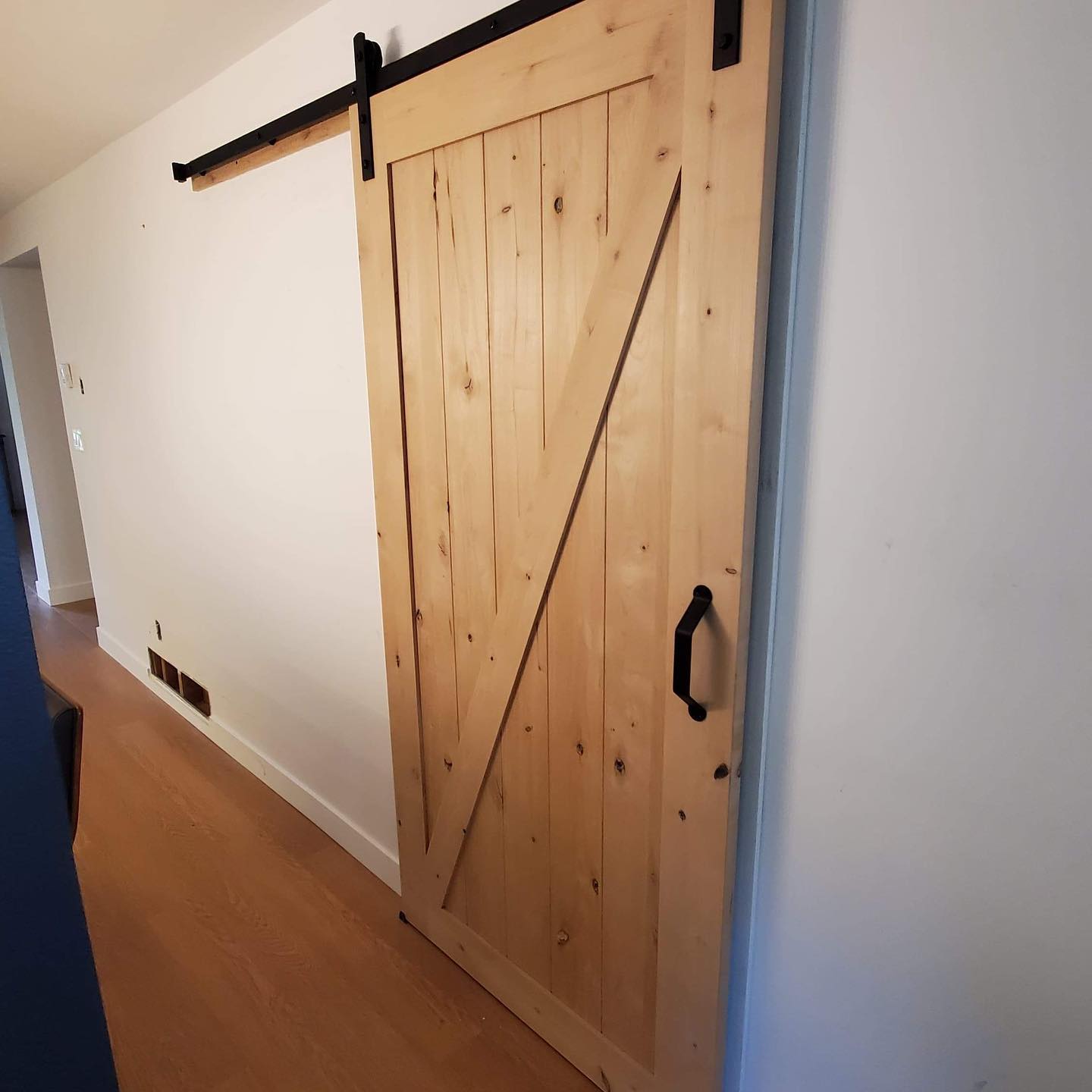 Barn door installation in the townhouse we just finished up!
This barn door is covering up a garage door in the kitchen which add a rustic touch to the front entrance hallway.