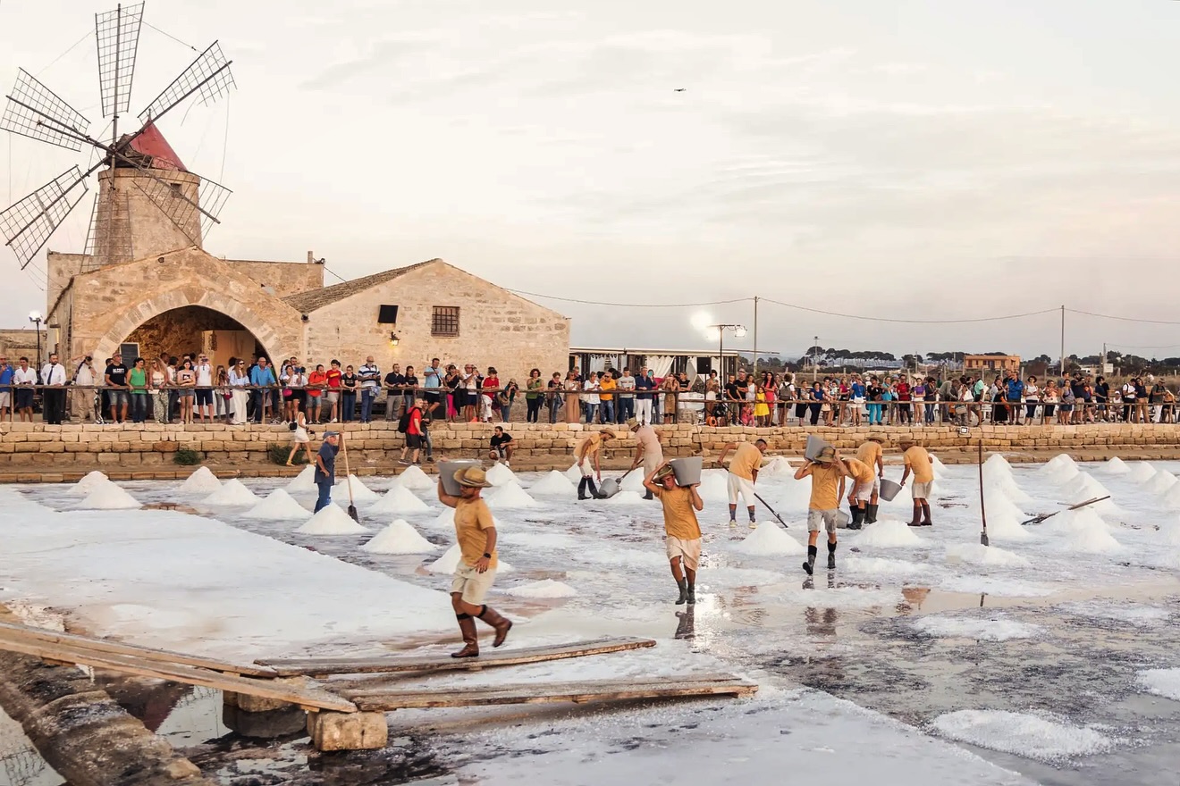 Le Saline di Trapani e Paceco non sono solo un panorama da cartolina; sono un organismo vivente dove l’uomo e la natura lavorano in un’armonia che dura da secoli.
Oro bianco, mani sapienti e un paesaggio che sembra dipinto coronano un’arte antica che ancora oggi dà sapore al nostro futuro.
Ti interessa sapere qual è il procedimento che trasforma l’acqua del mare in sale? Te lo riassumiamo brevemente in punti chiave:
1. Ingresso: l’acqua di mare entra nelle prime vasche (le “fridde”).
2. Evaporazione: grazie a sole e vento, l’acqua attraversa diverse vasche diventando sempre più salata e densa.
3. Cristallizzazione: nelle ultime vasche (le “salanti”), il sale precipita sul fondo formando una crosta bianca.
4. Raccolta: i salinai rompono la crosta a mano, accumulano il sale in piccoli mucchi per farlo scolare e poi creano le grandi piramidi esterne.
5. Riposo: i cumuli vengono coperti con le tipiche tegole di terracotta per proteggerli dalla pioggia.
Sapevate che il sale di Trapani è considerato uno dei migliori al mondo proprio grazie a questa lavorazione artigianale? 🧂
#TrapaniMonteErice #Saline