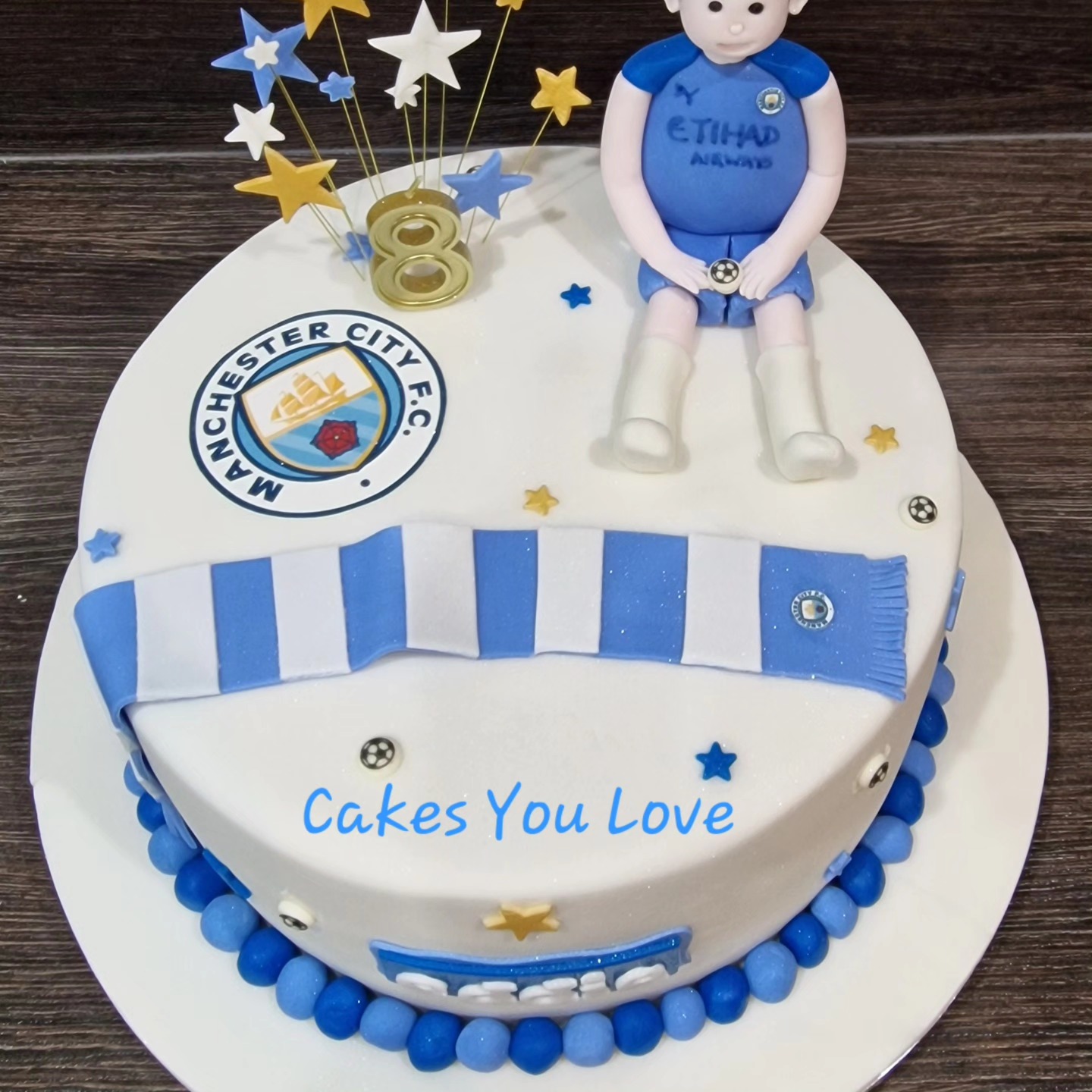 A huge chocolate sponge filled with vanilla buttercream. Decorated with fondant icing and handmade models. The images are edible printed images on icing.