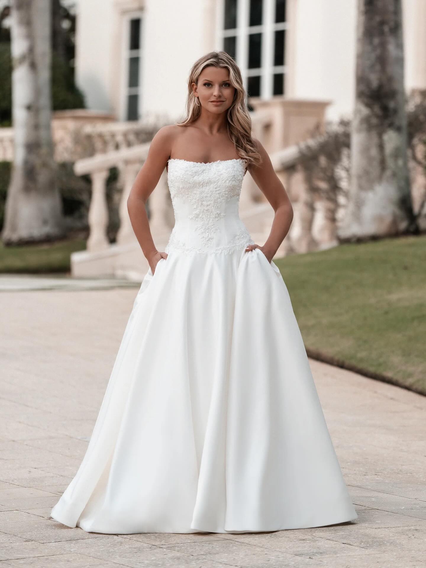 Softly lustrous satin and tonal beading bring quiet dimension to the bodice of this drop waist ballgown, framing a scoop neckline with subtle structure. The silhouette feels timeless yet elevated, offering a modern interpretation of a classic bridal silhouette. Say YES to this new @allurebridals arrival🤍🫶🏼