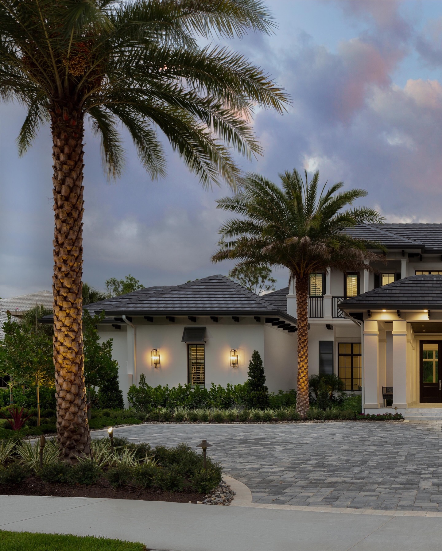 A home like this deserves an arrival that feels just as intentional as the architecture itself.
Framed by towering palms and a sweeping motor court, the landscape sets the stage before you ever reach the front door. Layered plantings soften the scale of the architecture while subtle landscape lighting carries the experience into the evening hours.
Thoughtful spacing, balanced symmetry, and coastal-resilient plant selections allow the design to feel refined while still thriving in the Southwest Florida climate.
Because the first impression of a home should feel just as extraordinary as everything that follows.
#NaplesLandscapeDesign #LuxuryOutdoorLiving #NaplesFloridaHomes #LandscapeArchitecture #OPIOutdoors