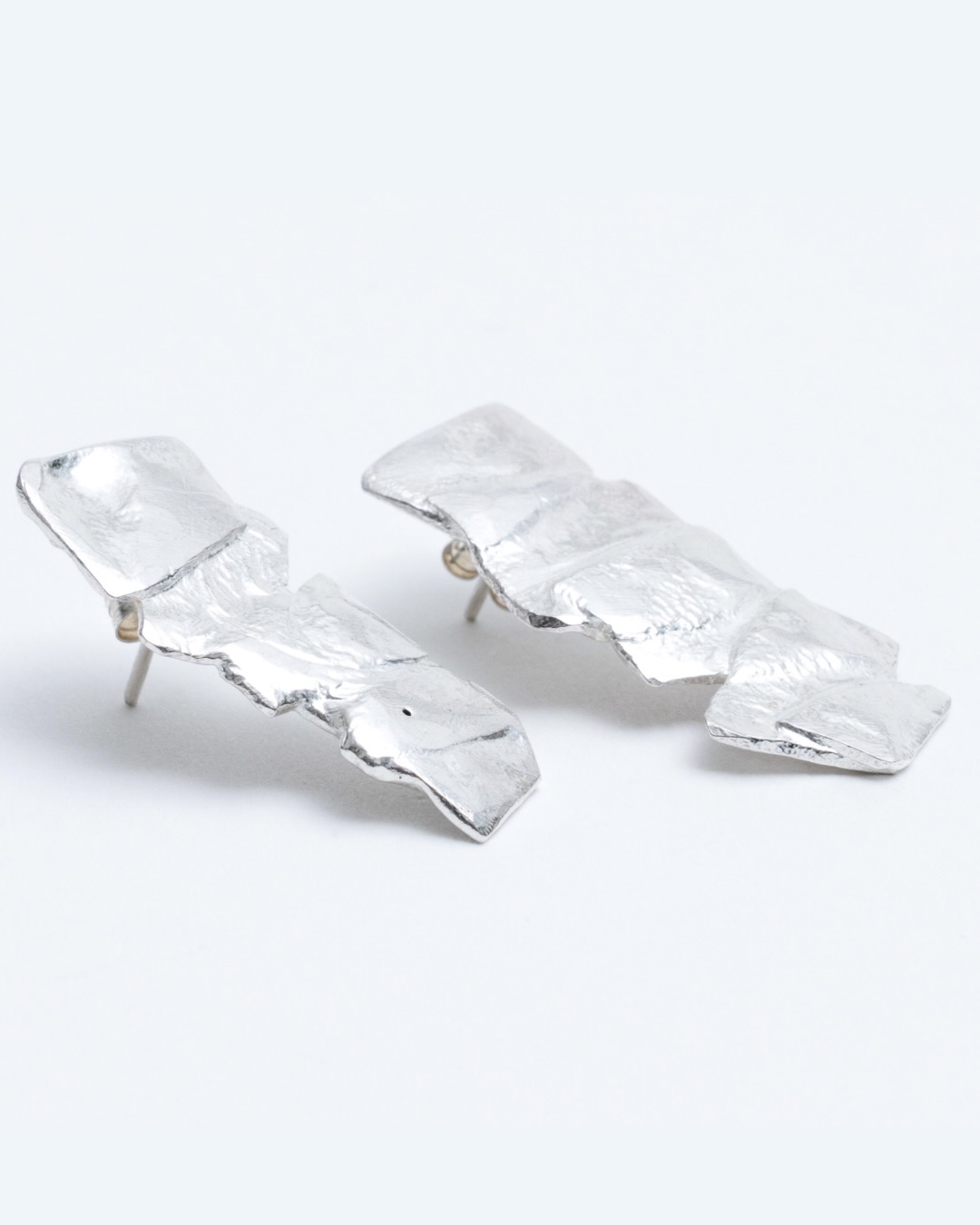 EL FUEGO — boucles d’oreilles
Six fragments d’argent façonnés par le feu.
La matière se tend, se plisse, se transforme sous la flamme.
Le feu ne lisse pas, il révèle.
Il laisse des reliefs, des marques, une énergie brute.
Chaque paire garde la trace de cet instant précis
où l’argent cède, se réinvente,
et devient bijou.