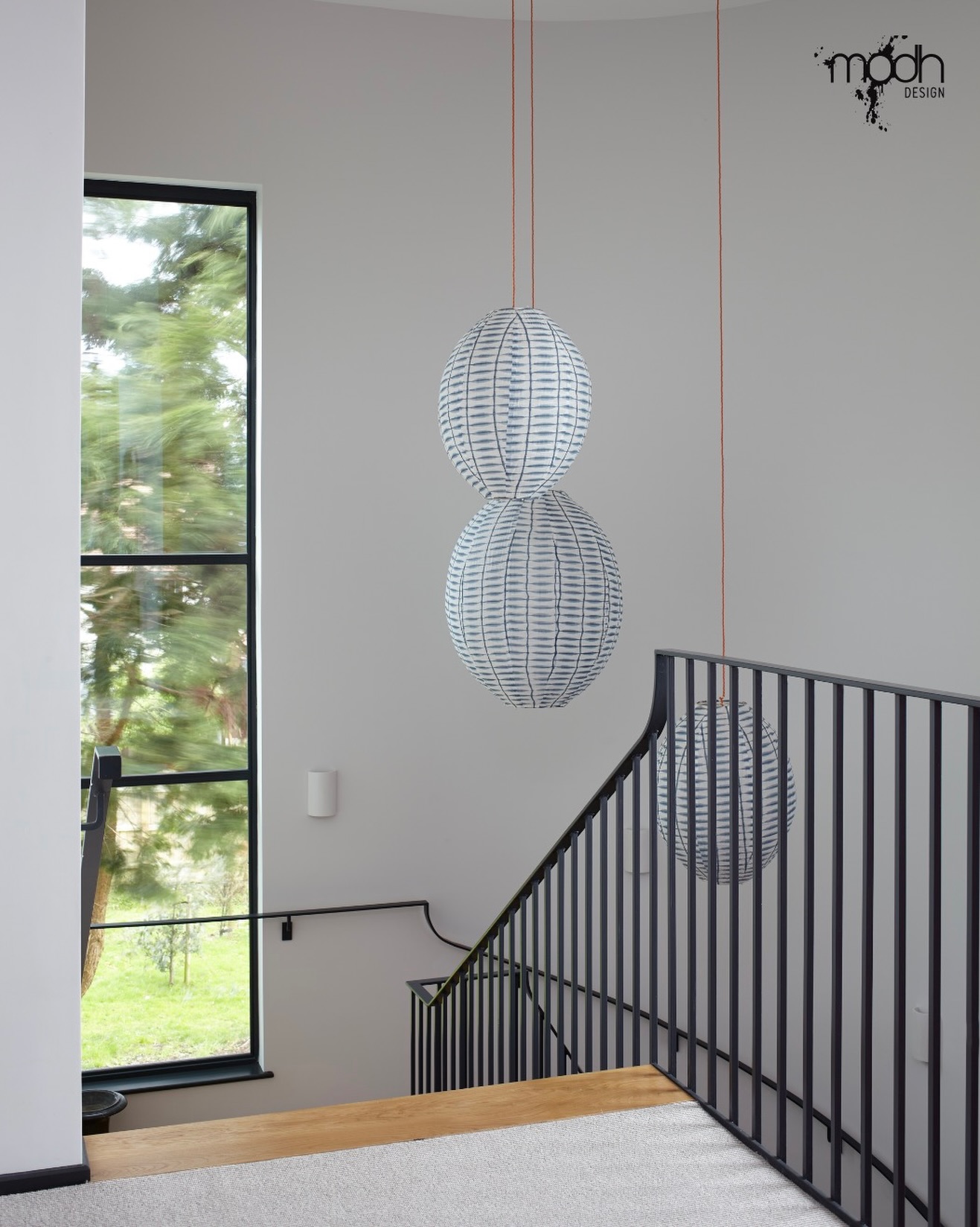 A simple stair space elevated by a full-height window and views beyond.