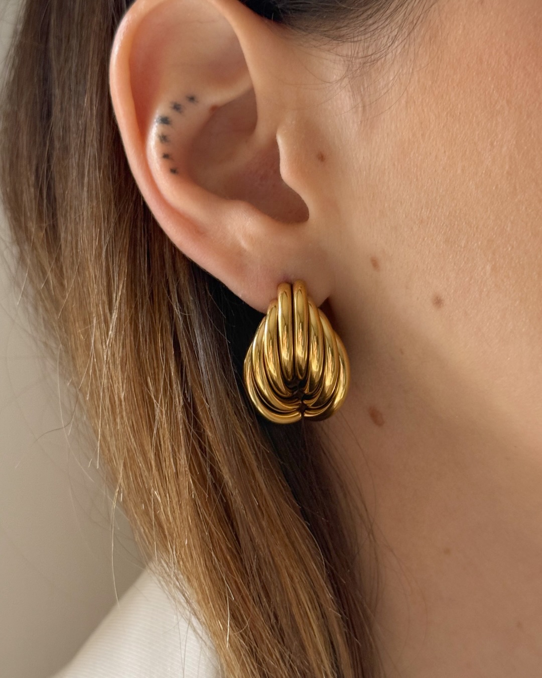 Ci sono trame che sembrano appartenere alla memoria.
Gli orecchini Alba ricordano quella della paglia intrecciata: la stessa sedia di casa, dei cappelli d’estate.
Certi oggetti che non hai scelto per fare scena, ma che finiscono per diventare parte di te.