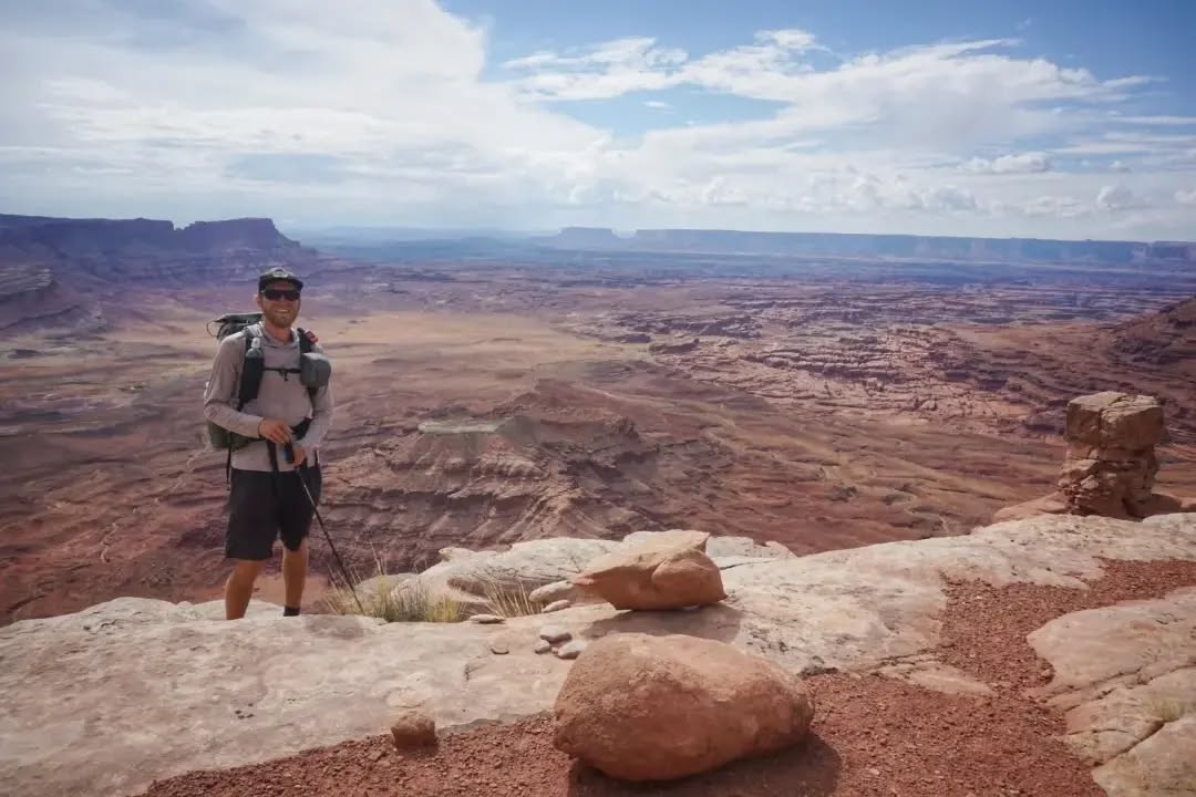 Hayduke Day 4 || Pritchett Canyon to Indian Creek (via Hatch Point Mesa)
I continued with some of Jamal's alternates today, and let's just say they had me questioning my choices. In the end I'm glad I did them, but they're not for the faint of heart.
After some quick jeep road miles I started on the first of today's challenges - scrambling down a rocky choked gully (2) to get down into Trough Springs Canyon. Then almost immediately I was climbing up the far side of the canyon (3) up to Hatch Point Mesa. Thankfully this climb was cairned and even had a thin footpath to follow.
The mesa was covered in yellow flowers and gave wide views all around (4). The only tricky part is getting off it. That involved a 1000 ft drop off the crumbled remains of a cliff, down a loose pile of steep rock and sand. Tricky and slow-going, it was one of those 'what am I doing here?' moments. But step by step I found my paths down and eventually, I could look back at the beast and marvel that I was just atop the thing an hour earlier (7).
Once down, I decided there was enough time to push on to the next water source. First on jeep roads, then dropping into the easy sandy bottom of Rustler Canyon, I made good progress. As the light faded there was a storm on the horizon which flashed lightning every few minutes. Minutes after I pulled out my phone for a bit of light to hike, I rounded the corner to the confluence of Indian Creek. Only there was no creek. Just sand. And this was suppose to be a fairly reliable source. Hmmm. As I started up the creek, which was my path anyway, I began to see damp patches of sand. Eventually I found a puddle deep enough to gather water, just as the first drops of rain started overhead (update: there were a couple more and larger pools further up the canyon, but no flowing water). I set up my shelter in the dark and settled in for a late dinner, which I promptly spilled into the sand (half remained). I've got lots of food, so it's mostly a clumsy inconvenience. I must be tired.
#thruhike
