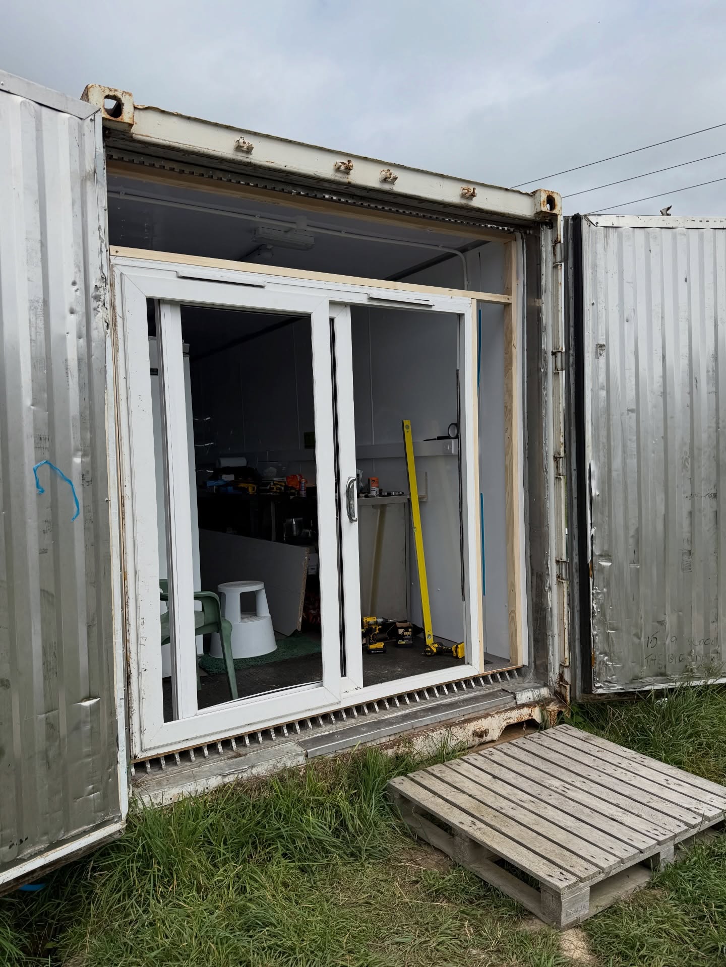 A New Chapter 🌱 – Part 8
Building a Vertical Farm
This was the stage where everything started to come to life and we could finally see light at the end of the tunnel (figuratively and literally 😅).
Steve handled most of the build himself — this is our fourth farm build so he’s a seasoned pro — but fitting the door definitely needed another pair of hands, so our good friend Ian stepped in to help.
Ventilation was a big piece of the puzzle. Steve used the container’s original refrigeration framework to build our own ventilation and air filtration system — pulling cooler filtered air in from the bottom while warm air escapes from the top to keep airflow moving and conditions stable.
A germination chamber was also built (something Steve had always wanted) so seeds can start life in their own perfectly controlled environment.
Racking went up, lights were installed, trays appeared — and then the crops followed. At that point a glass of prosecco was poured and we just sat there grinning like the Cheshire Cat.
We’ve had to adapt our plan over the last six months. Our storage container was delayed so we sacrificed some growing space for storage through winter, but with tourism ramping up those areas will soon be back in production 💪
The staff kitchen is being moved so Nina can harvest alongside Steve. She’s done most of the sowing since joining her dad last year and seeing her step into harvesting and packing has been brilliant — we’re incredibly proud.
Two containers and a linking corridor later… we’ve built a microgreen growing powerhouse 🌱
Next up: cladding the outside (and we definitely called in the troops for that one!).
#FTMF #FreshAndTastyMicrofarm #ANewChapter #VerticalFarming 🌱