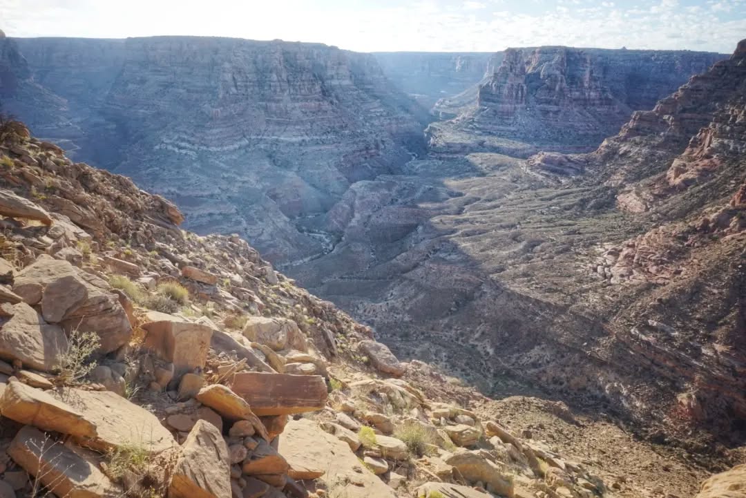 Hayduke Day 9 || Dark Canyon to west fork Rock Canyon
A day of road walking, book-ended by some wilder stuff. I started with an immediate climb up the Sundance Trail, a 1200 ft climb straight up out of Dark Canyon (yep, started at the very bottom of image 1 and still had a bit higher yet to go). It was a sweatier start to the day than I would have hoped, since there would be no water until 16 miles later at the public restrooms of the Hite ranger station. Along the way I ran into another Hayduke hiker (my first!), although technically he was driving in a car, setting up caches for his upcoming hike. We chatted for a while at the dirt road before we each went our separate ways with plenty of miles each still to cover for the day.
Hite visitor centre is a 1.7 mi detour off the road, but it's the only water around so bonus miles for me! There's also shaded picnic tables, outlets, toilets, and trash cans, so it's not a bad spot to spend the hot afternoon. I finally hiked out after a couple hours and crossed the Colorado River for the 2nd time since Arches, then swung east and north into Rock Canyon with 7 litres of water in my pack - enough for the night as well as all day tomorrow.
#thruhike