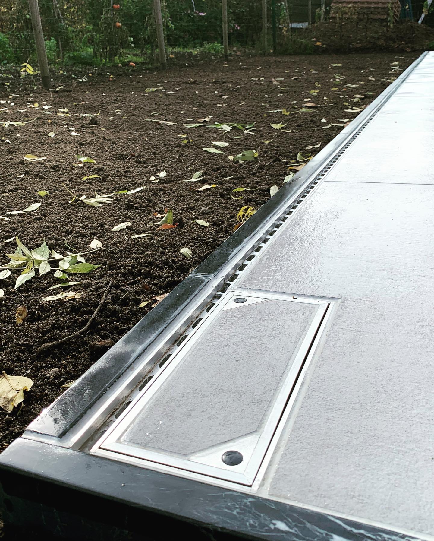 Keramische tegels 80x80 in combinatie met blauwe hardsteen en discreet afvoergoot