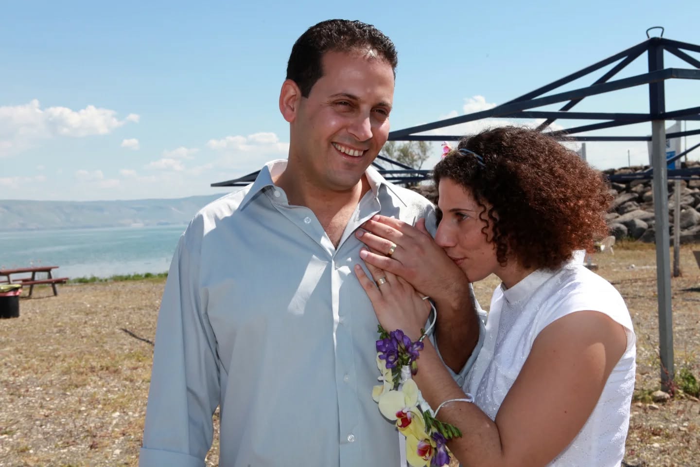 לפני 15 שנה הדר ואני נסענו ברכב, אני זוכרת בדיוק את הנקודה קצת אחרי צומת יזרעאל שהשיחה התגלגלה והחלטנו, שמתחתנים.
(זה אולי ישמע מוזר להרבה זוגות אבל לנו זה בדיוק מתאים)
הדבר הראשון שעשיתי היה לברר עם אמא שלי אם היא שמרה את השמלה שלה כי זה מה שהכי רציתי ללבוש וכמה שמחתי שהיא לא הפכה אותה לכיסוי לכריות כמו שהיא התכוונה .
היה לי אז עסק לעיצוב אירועים ועבדתי עם הגן המקסים של מלון נוף גינוסר
וכל עניין ההפקה הרגיש לי הכי פשוט בעולם.
קבענו תאריך לבדיוק עוד שלושה חודשים וכל הספקים הקבועים קיבלו ממני טלפון.
אנחנו (כמו שאנחנו) רצינו הכל הכי פשוט,
אני זוכרת את השיחה עם הבחור מהבר,
הדר אמר לו, אני רק רוצה שהבירה תיהיה קרה ושהברמנים יחייכו,
פחחח
היו בר שייקים וכוסות גבוהות של קווה עם תותים.
אף אחד מהאנשים הנהדרים שלקחו חלק בחתונה שלנו לא חשב שזה צריך להיות פשוט, אז בסוף היה אירוע עם מוסיקת עולם שמרעידה את הלב,
פינות ישיבה נמוכות עם מזרונים וכריות, מלצרים שמסתובבים עם המון מנות ביס קטנות, כל אחת יותר טעימה מהשנייה,
(אני יודעת את זה רק בזכות גיל, השף של המלון שארז לנו הכל למחר).
אני גם זוכרת שהתקשרתי לרב דידי, הכרנו קצת מהעבודה במלון, ושאלתי אם הוא יכול לעשות לנו חופה קצרה שמתאימה לזוג הקיבוצניקים החילונים שאנחנו,
השאלה באה אחרי ששמעתי אותו נותן דרשות של שעה בחתונות של מקובלים מטבריה,
הוא צחק ורק שאל מתי אני רוצה שהוא יגיע.
היה יום מושלם, וצחקנו מלא ועד היום אני יודעת שבחרתי נכון. באיש אחד שעדיין מצחיק אותי בכל יום, שגורם ללב שלי לרקוד ושנתן לי את שתי הבנות הכי נפלאות בעולם.
יאללה מותק, לעוד 15 שנים כאלה, בבקשה.
(ואל תכעס שאני מביכה אותך ככה מול כולם)