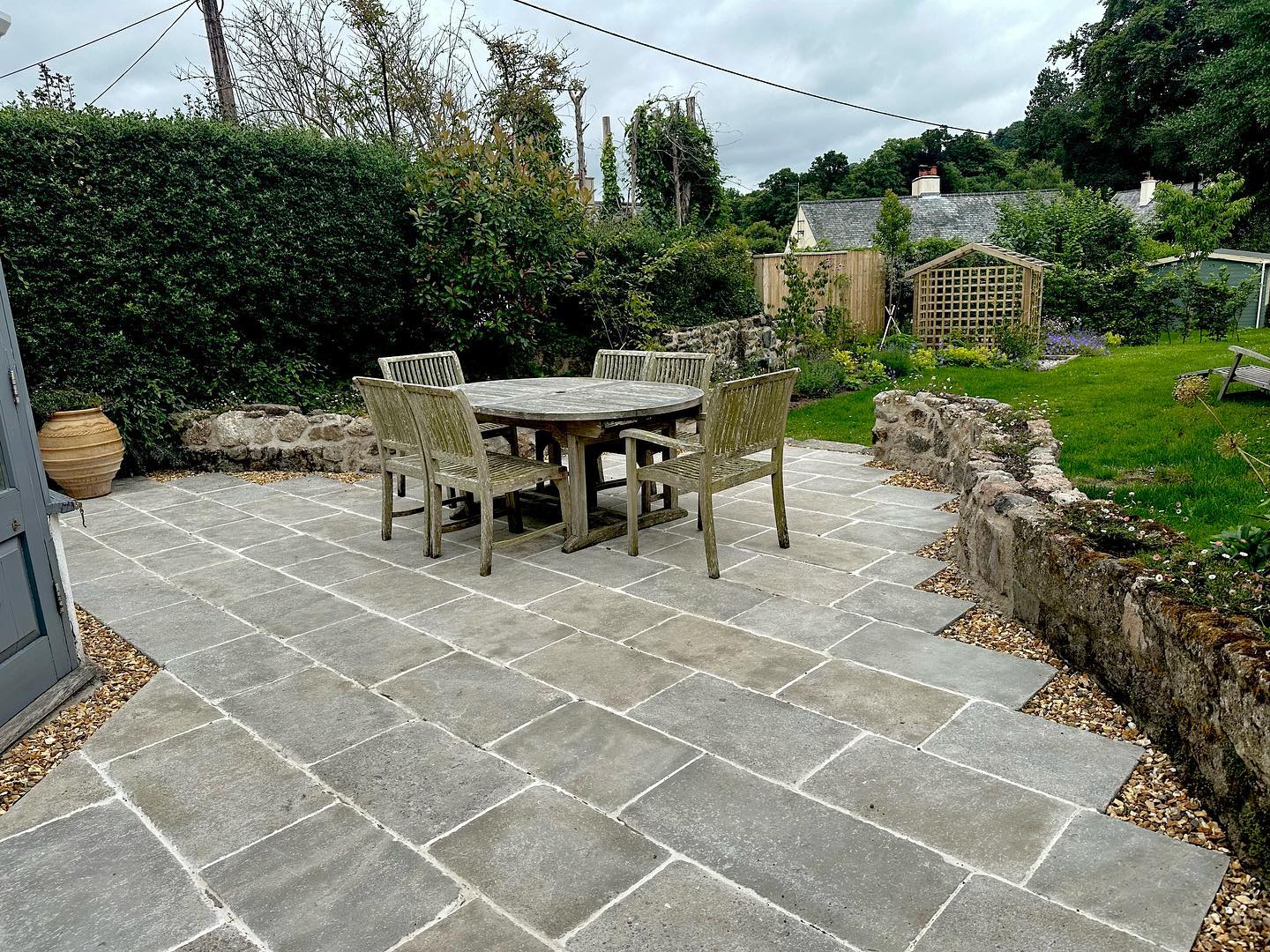 Another project finished 💪 The previous terrace had subsided so we had to excavate the whole site before a new membrane and sub base were installed. Thank you to @quornstoneofficial for these Clermont Gris Limestone pavers which is finished with @kerakolluk Fugebella grout to give us that country house finish. To create a larger entertaining area, we removed the central granite wall and extended the side walls framing the terrace beautifully. We designed the walls to allow for the planting of Erigeron, this clump forming perennial will break up the hard edges of the granite as it gets more established. Finally finished by bespoke pickets for our fence and gate and fabricated steel archway ready for the planting of a @david_austin_roses #landscapedesign #landscapedesigner #landscape #gardendesign #landscapeideas #outdoordesign #landscapearchitect #landscapegarden #gardenlandscape #landscapelovers #landscapingideas #landscapes #landscaping #chagford #devon #exeter