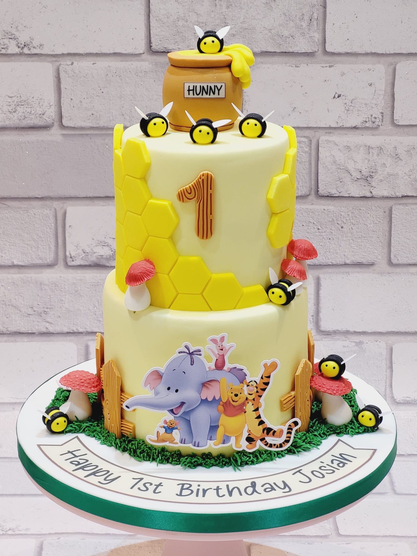 Sweet as hunny and twice as cute 🍯🐝
This adorable 1st birthday cake is inspired by the magic of Winnie the Pooh and friends, featuring a playful honey pot topper, buzzing little bees, and soft pastel tones for that perfect first birthday feel. Finished with hand-crafted details and a personalised touch for Josiah’s special day 💛
A cake full of charm, character, and childhood nostalgia ✨
#FirstBirthdayCake #WinnieThePoohCake #KidsBirthdayCake #northwalescakes