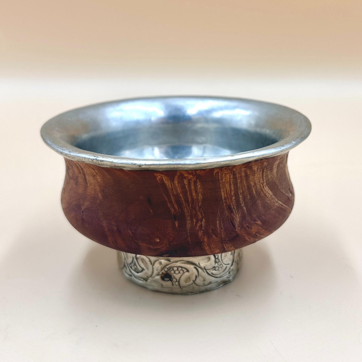 🟢 DOSTĘPNA | Tradycyjna czarka, Tybet, l. 80 XX w.
Czarka tybetańska z drewna brzozowego ze srebrnym wkładem i stopką zdobioną ornamentem roślinnym.
W Tybecie ograniczony dostęp do gliny wysokiej jakości oraz warunki klimatyczne sprzyjały wykorzystaniu materiałów łatwiej dostępnych i trwalszych, takich jak drewno i metal. Drewno zapewniało lekkość i izolacyjność, natomiast metal/srebro zwiększał wytrzymałość i prestiż naczyń, zwłaszcza w kontekście rytualnym.
80 ml
350 PLN + 20 PLN koszt przresyłki