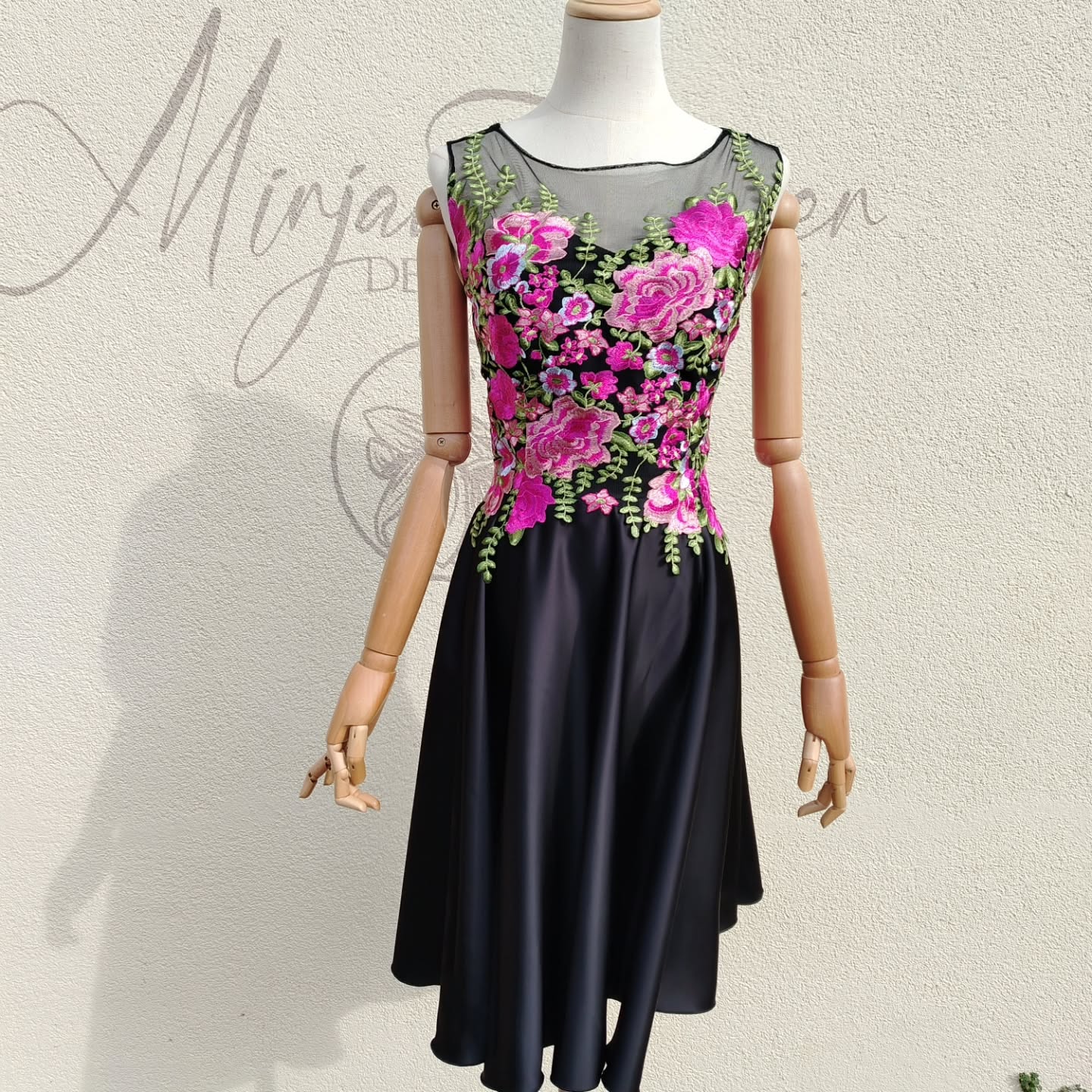 Kurzes schwarzes Ballkleid mit pinker Spitze.