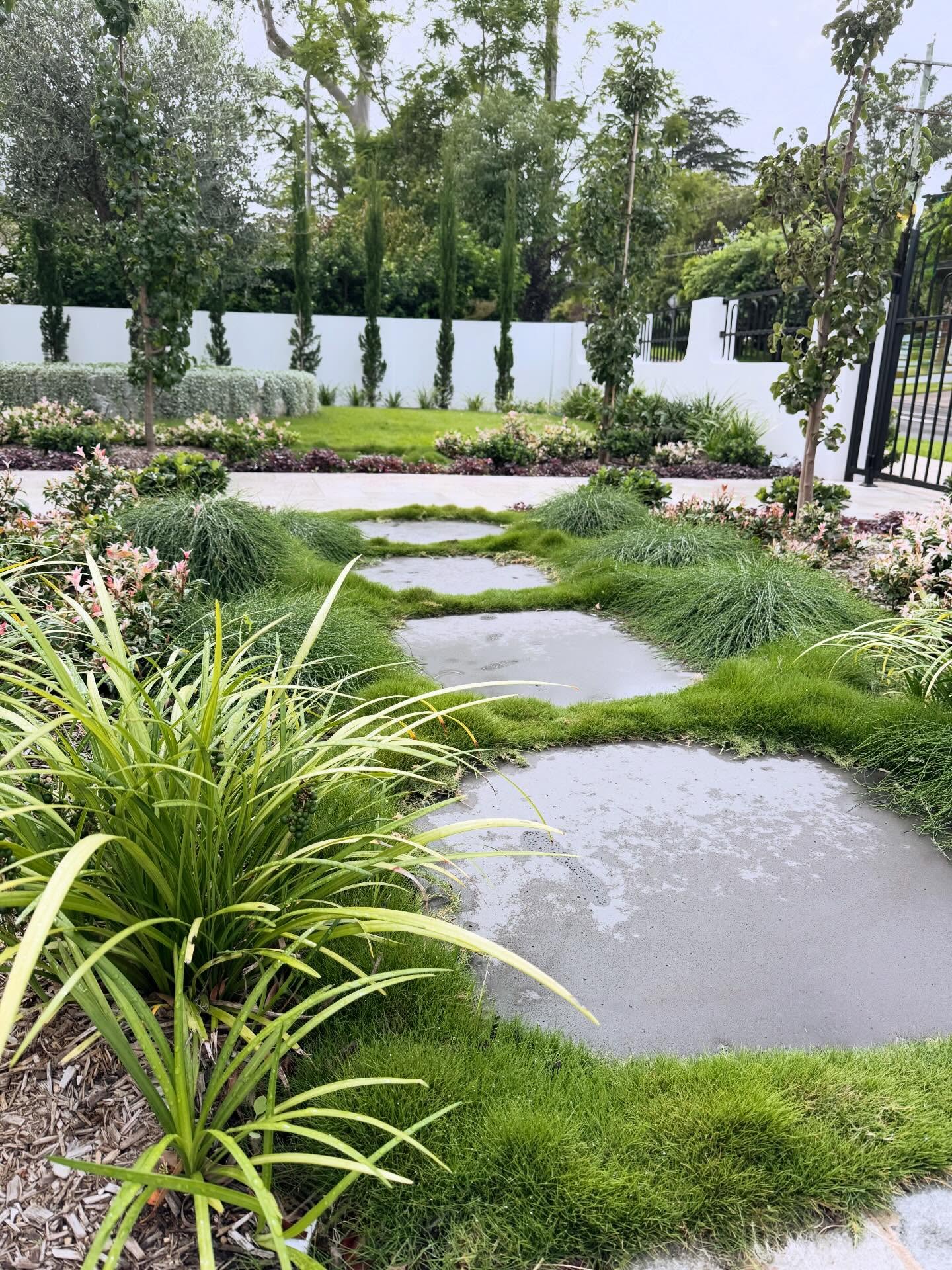 Organic shaped bluestone stepping stones helping to create a seamless connection between the driveway and front pathway. This space is complemented with a curated mix of plants to soften and balance the surrounding hardscape.
Landscape design: @villageavelandscapedesign
Landscape construction: @meakscapes