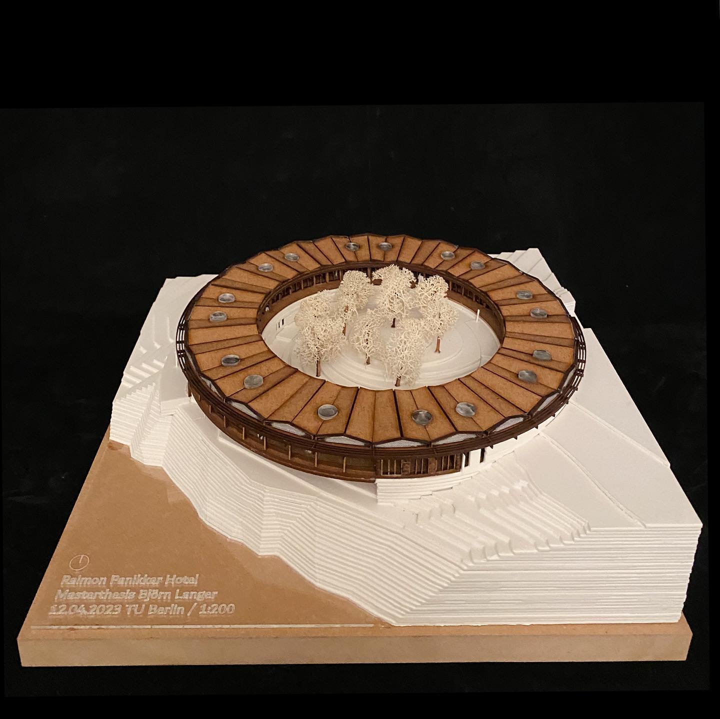 Project 3
Eco Hotel Catalonia
Named after the Tavertet living Catalonian philosopher, Raimon Panikkar (1918-2010). The Raimon Panikkar Hotel design follows this philosophers ideas around the interconnection between nature and humanity, rather than commercially exploiting the site with a human-centric, solely view-oriented volume. The hotel places nature at its center and raises environmental awareness among visitors.
Built with local granite and wood/clt in a strict 3m grid alone, the construction is completely prefabricated in elements; lowering construction effort and environmental impact.
The granite walls carve out of the mountain and are topped with a light wooden construction that reflects the surrounding nature where the trees grow out of the cliffs. A site visit showed a natural spectacle, defining the genius loci.
Due to the climatic conditions of the Pre-Pyrenees in combination with the Panta de Sau, intense morning fog develops.
A low-tech design with fog collectors and solar chimneys can harvest the fog and create natural ventilation. The naturally collected water and the solar panels on the roof allow the hotel to function primarily self-sufficient.
Beneficial impact on the local community, the hotel creates jobs for regional employees. Guests can stay for a few hours or several weeks and enjoy the local cuisine, relax in the spa, visit workshops for sustainable tourism and species protection, and above all reconnect with nature.
#architecture #architect #architecturemodel #architectural #maquettearchitecture #lasercutting #masterthesis #circle #bestnewarchitects #modelarchitecture #potd #new #realestate #design #designhotel #larsenliverpool #architecturecompetition #woodarchitecture #ecofriendly #newpost #architecturelovers #studentwork #archiporn #archigram #hotel #newartist #arquitectura #arch #discover #architecture_hunter