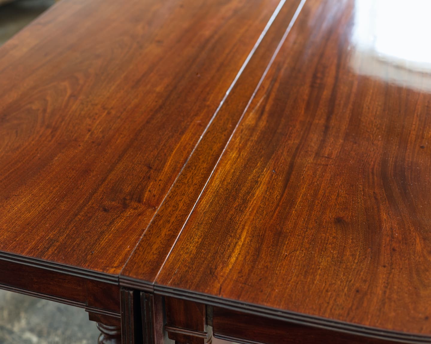 Banquet tables offer a nice range of sizes. With the drop leaves up, you have a very large table. You can raise just one leaf (which will rest on the edge of the other drop leaf) for a good medium size. But when both leaves are down you run into a problem: how do you keep both halves from moving separately from each other? And keeping the drop leaves from knocking into each other?
The answer is this narrow strip of mahogany which snuggly fits between each half of the table. Small areas were cut away to fit around the tenons coming off the back edge of the tops (to eliminate side to side movement) and some oak pins were added to go down into the drop leaf mortises (to keep the ends of the table together). The pins were screwed in (plus an additional drop of glue) instead of mortised in to make repairs easier if one breaks off. The barrels of the hinges had to be accommodated as well.
The table was otherwise in very good condition, requiring only two small areas of missing veneer to be replicated and a repair to one gate leg before French polishing the existing finish.
#furniturerestoration #furniturerestorer #banquettable #mahoganydiningtable #diningtable #frenchpolish #frenchpolisher #shellac #restoredinbaltimore