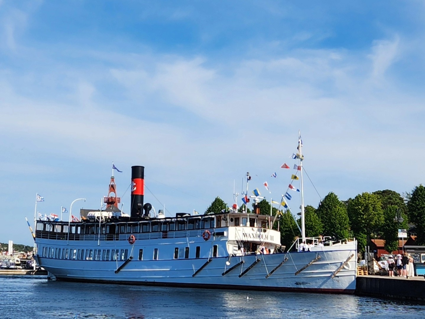 Day 2 in Stockholm brought perfect weather for a full-day Thousand Islands Tour—a memorable journey through Sweden’s archipelago, where boat culture, especially in summer, is a way of life.
The cruise goes from Lake Mälaren out to the open Baltic Sea, stopping at three very different islands, each with its own character:
Kymmendö – Peaceful trails and literary history, once home to Strindberg’s inspiration
Bullerö – A remote nature reserve with a small art-filled museum and untouched coastal beauty
Sandhamn – A lively sailing village with narrow streets, cafés, and seaside charm
The warmth of the sun on the islands contrasted with the cold breeze at sea. They instruct you to pack layers for a reason.
Onboard the classic M/S Waxholm III ship, morning coffee, lunch, afternoon fika, and a two-course dinner were served.
I met some truly lovely people: a Canadian couple, a mother and daughter from Basel, Switzerland, and my tablemate Anita from Sweden—a retired therapist. We were the only solo travelers on board and shared both lunch and dinner, chatting about travel, life, and our husbands back home. Our server from L.A., with Midwest roots and a Swedish dad, was a sweet young woman aspiring to be a writer.
I was a bit hesitant to book a full-day tour, but it turned out to be wonderful—and absolutely worth it!