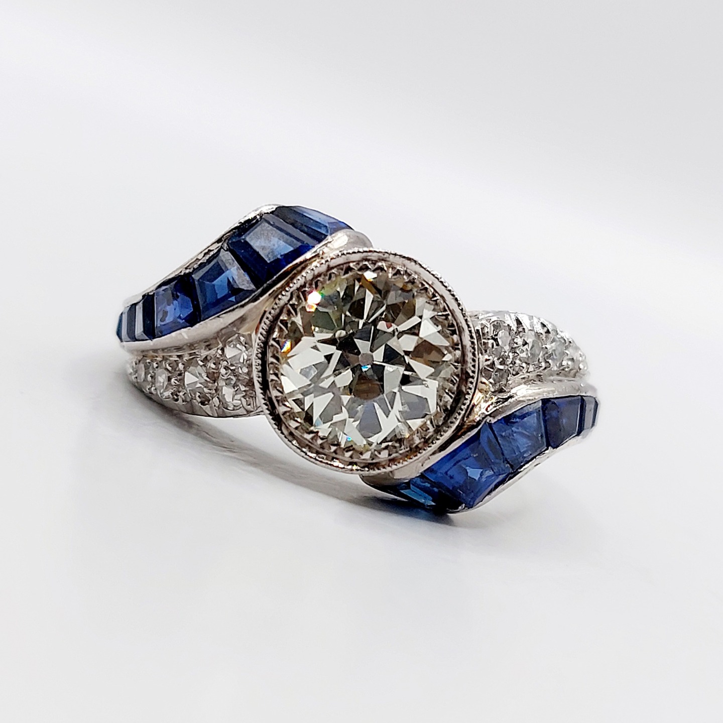 French Art Deco ring 18k white gold set with a 1.60 carats old european cut diamond surrounded by calibrated sapphires and transitional cut diamonds in a finely guilloché mounting (circa 1920)
PRICE : 8900€
Magnificent and rare French Art Deco goldsmithing
Size: 54.5 FR / 7 US
Weight: 5.87 g
Diamond size: approximately 7.5 mm (estimated at 1.60 carats)
Diamond in perfect condition, European old cut
Color: estimated K/L (Slightly tinted/yellow)
Clarity estimated: VS1 or VVS2, inclusions very difficult to see with a loupe
Ring width: 10 mm
Micro scratches from use and slight wear to the sapphires visible only with a loupe
Owl hallmark (French hallmark)
#frenchjewelry #diamond #diamondring #antiquering #victorian #victorianring #marquisering #augustusjewels #vintagering #daisyring #daimondhaloring #tragetring #oldminecut #oldminecutdiamond #oldeuropeancutdiamond