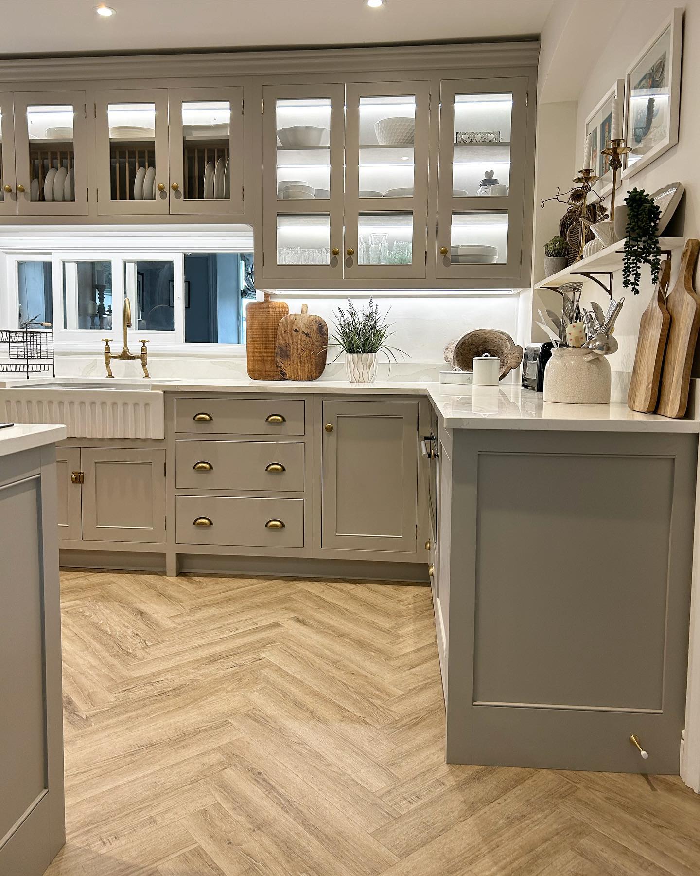 A wall of made-to-measure cupboards in this countryside Victorian house. Glass fronted cabinets with inside lights illuminating the kitchen, making the most of the high ceilings. Both gloriously practical and beautifully simple.