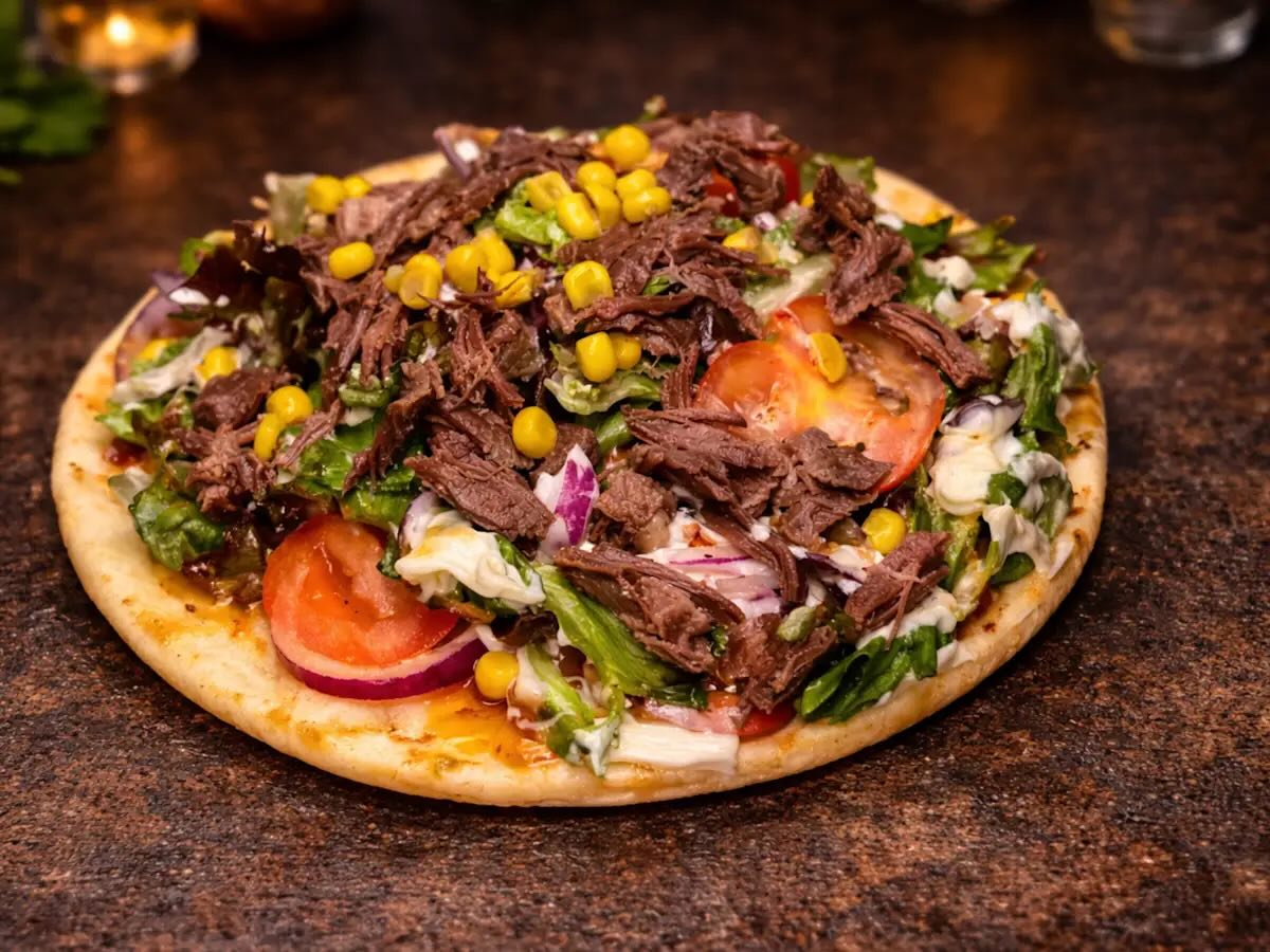 BBQ Pulled Beef Flatbread
£7.99
Soft flatbread topped with tender shredded beef, fresh lettuce, tomato, red onion, sweet corn, and finished with creamy house sauce