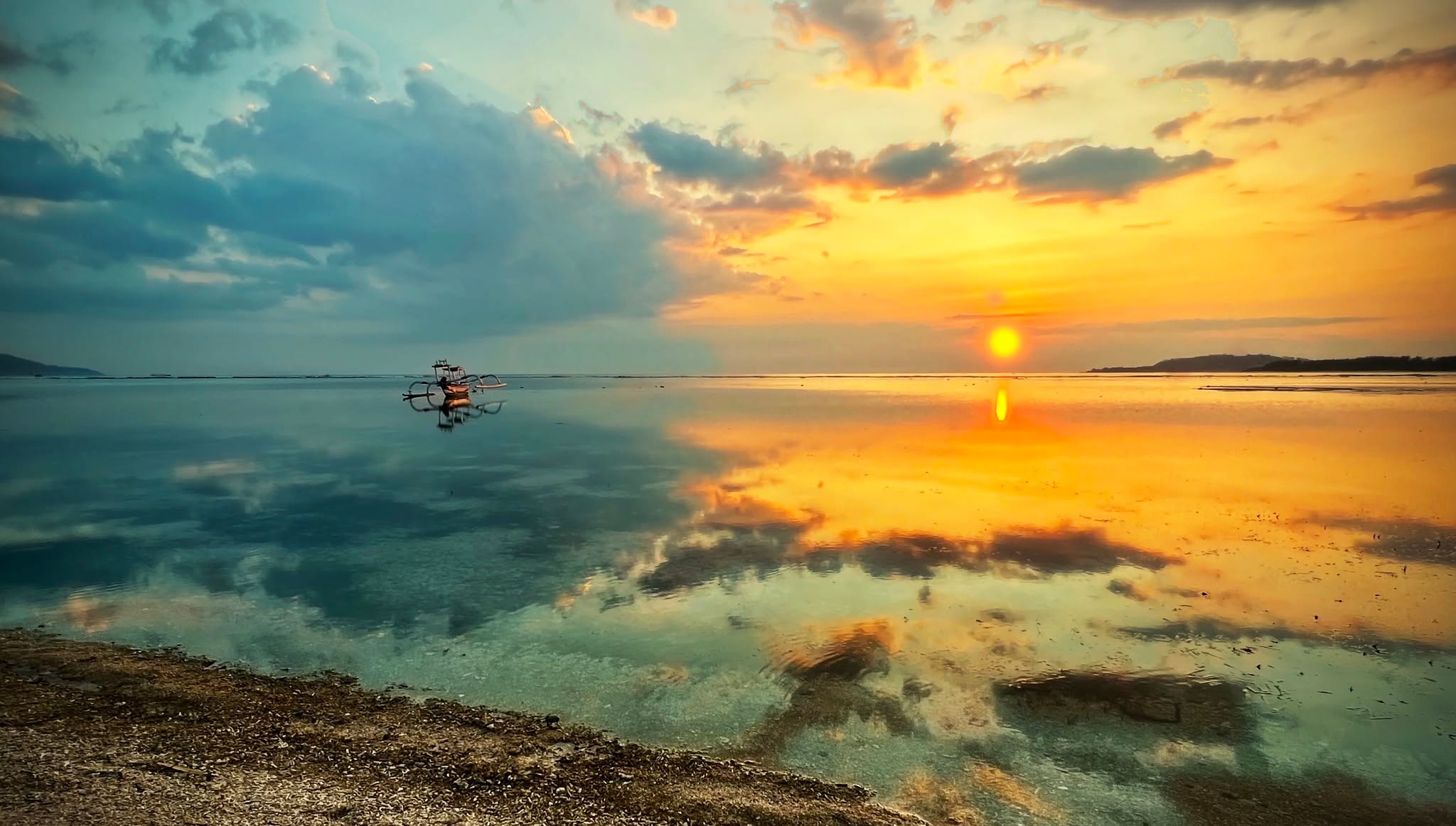 Captain’s Log: Half Ice, Half Fire
I came across this photo today from Gili Air in Indonesia. It always jumps at me! The water was so flat it turned into a mirror—half ice, half fire, a clean juxtaposition. It’s the balance that keeps you out here—effort and reward, grind and payoff, all living side by side. One horizon behind you, another one waiting ahead. This is home and forward motion at the same time. And somewhere between the two, you realize the adventure never really ends—it just changes shape.
I moved from Punta Arenas today, finally off the dock and fully provisioned. Nailed the timing—high tide—so I had a clean 8 to 10 feet under me instead of playing fiberglass roulette. Easy motor over, no drama, no crunching noises. Dropped the hook off Isla Cedros, tucked into a small cove that feels like it was built for hiding from bad decisions and worse weather. No rush—Papagayo is ripping for at least two more weeks, so consider this a forced intermission. I’ll kick it here for a bit, enjoy a couple of great spots, and maybe slide over to Tamarindo late next week to chase a few waves.
Today’s agenda is simple: clean the bottom, then sit down and write. And write. And keep writing. Working on the book—trying to take these big, fully lit, 25-page moments and compress them into something a normal human might actually read. Turns out that’s harder than crossing an ocean. You live it one way—big, loud, sprawling—and then you have to shrink it down without losing what made it matter. I’m learning as I go, because apparently “just write everything” isn’t how books work, and a 4,000-page novel might be a tough sell.
Days Sober: 2,275