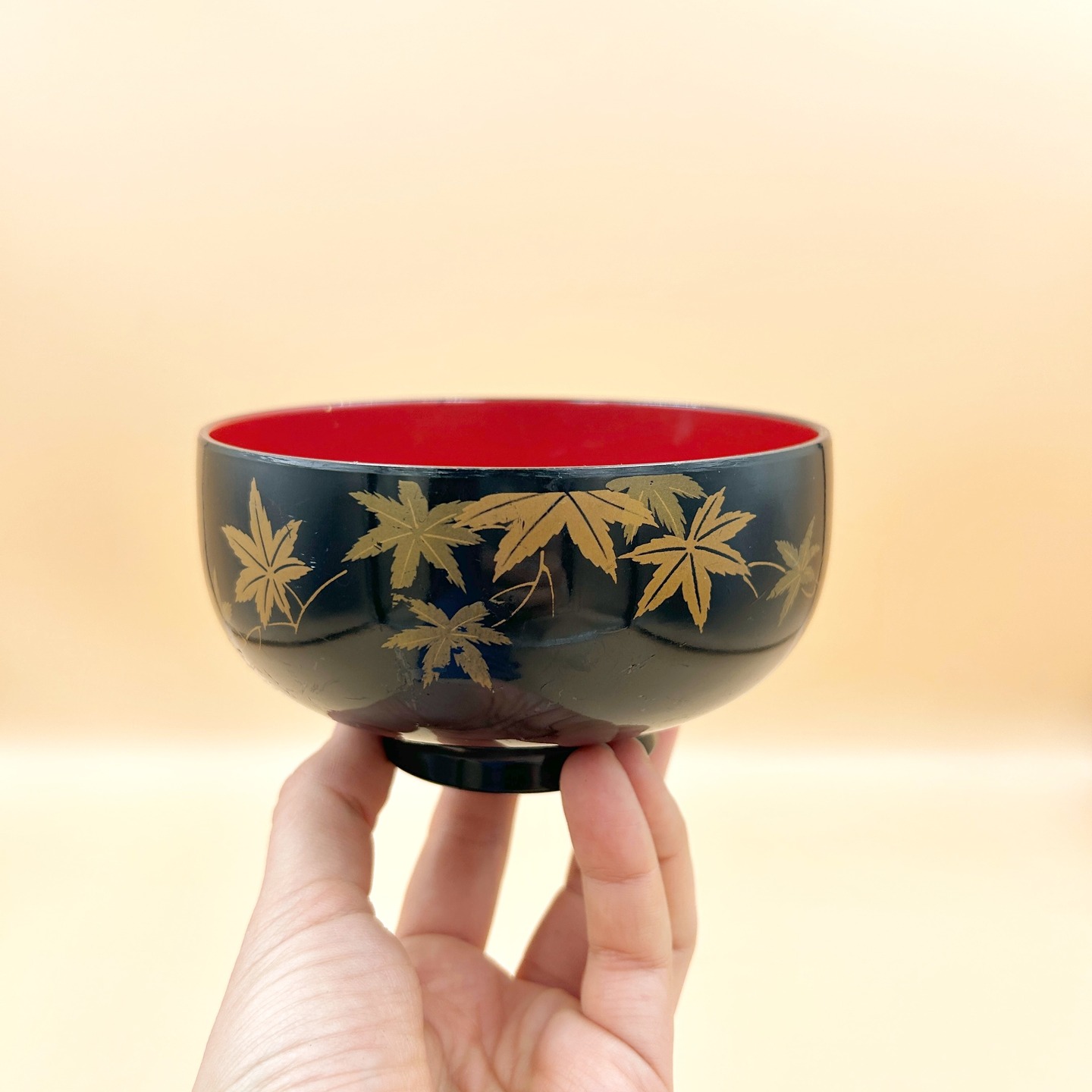 Zupówka/ wieksza ryżówka z motywem liści klonu, Japonia, II poł. XX w.
Wykonana z trwałej, syntetycznej laki indywidualna miseczka do ryżu do posiłków w tradycyjnym japońskim stylu.
Miseczka wykończona jest soczystą czerwienią w środku z kontrastowym, czarnym zewnętrzem, co jest charakterystyczne dla japońskich wyrobów użytkowych z XX wieku.
Zewnętrzną powierzchnię miseczki zdobi stylizowany motyw liści klonu japońskiego (ine), przedstawiony w złotej dekoracji o płynnej, linearnej kompozycji. Motyw klonu (momiji) w sztuce japońskiej symbolizuje przemijanie i piękno ulotnych chwil, szczególnie w kontekście jesiennej zmiany barw liści. Jest często wykorzystywany w malarstwie, rzemiośle i poezji jako element estetyki mono no aware, podkreślającej melancholijną refleksję nad nietrwałością świata.
Dobrze leży w dłoni, świetnie zaprojektowana.
Na etykiecie widnieje standardowa japońska informacja o jakości i materiałach.
Poj. 450 ml
Stan dobry (zarysowania od zewnętrznej strony wyniakające z użycia).
45 PLN + 15 PLN koszt przesyłki