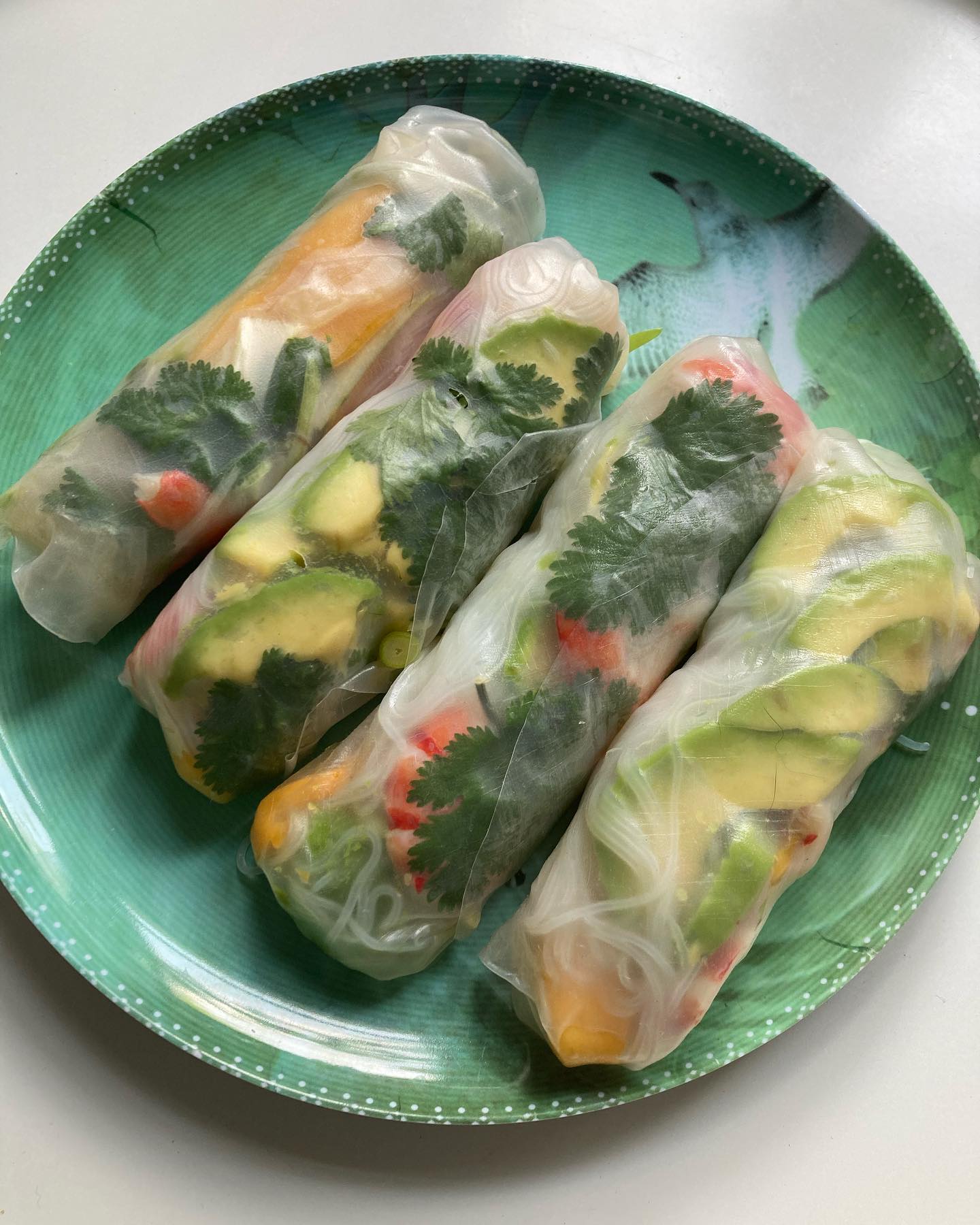 Rouleaux de printemps aux crevettes, mangue et avocat!
J’en fais quoi de ma super jolie mangue aux couleurs inouïes? Des rouleaux de printemps, puisqu’on est le printemps bien sûr! En version mangue, avocat, crevettes (mais on aurait aussi pu les préparer avec du saumon cru en fines tranches). J’ai encore à améliorer mes pliages… mais c’était quand même très bon! On peut les servir avec une sauce à nems, toute prête; j’ai préféré faire une petite sauce cacahuète.
Pour 4 personnes (8 rouleaux): 8 feuilles de riz rondes, 1 mangue, 1 avocat 1/2, 16 crevettes cuites, 70g de vermicelles de riz, 1 bouquet de coriandre fraîche, 1 tige d’oignon vert.
Pour la sauce: 2 c.à soupe de pâte de cacahuète non sucrée, 2 c.à soupe de sauce soja claire, 2 c.à soupe de vinaigre de riz, 1 c.à soupe d’huile de sésame grillé.
Plonger les vermicelles de riz dans de l’eau bouillante. Éteindre le feu et les laisser cuire 10mn. Les passer sous l’eau froide, les égoutter.
Préparer tous les ingrédients de la garniture. Enlever les carapaces des crevettes, les couper en 2 dans l’épaisseur.
Remplir un plat d’eau. Plonger dans le plat chaque feuille de riz puis les étaler sur un torchon propre.
Sur la partie avant, à 4ccm du bord, déposer 4 demi-crevettes, puis par dessus, les tranches de mangue, un peu de vermicelles, d’oignon vert, de tranches d’avocat et des feuilles de coriandre. Rabattre le bord sur l’ensemble, ainsi que les 2 parties latérales, pour bien fermer les extrémités, puis rouler de bas en haut, bien serré, l’ensemble des ingrédients.
Préparer la sauce en mélangeant tous les ingrédients.
A savourer immédiatement avec la petite sauce!
Bonne dégustation!
#rouleauxdeprintemps #springrolls #mangue #mango #avocat #avocado #avocats #coriandre #coriandrefraiche #crevettes #cusinevietnamienne #cuisineasiatique #asianfoodie #dietetiquechinoise #madreperlamtc