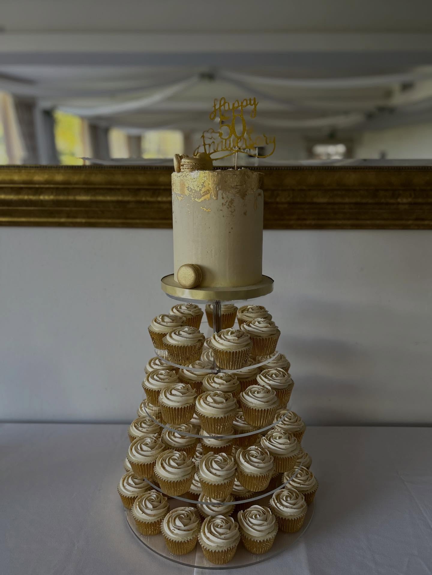 Golden elegance for a golden milestone ✨
This stunning cake tower was created to celebrate an incredible 50 years of love and marriage 💛
textured gold-leaf cake, delicate macarons, and a full tower of hand-piped cupcakes with gold sprinkles.
Set @kingsnortongolfclub this display was the perfect centrepiece for such a special anniversary.
Here’s to 50 years of memories, laughter, and love — and many more to come 🥂
#GoldenAnniversary #50YearsOfLove #CakeTower #LuxuryCakes #CupcakeTower