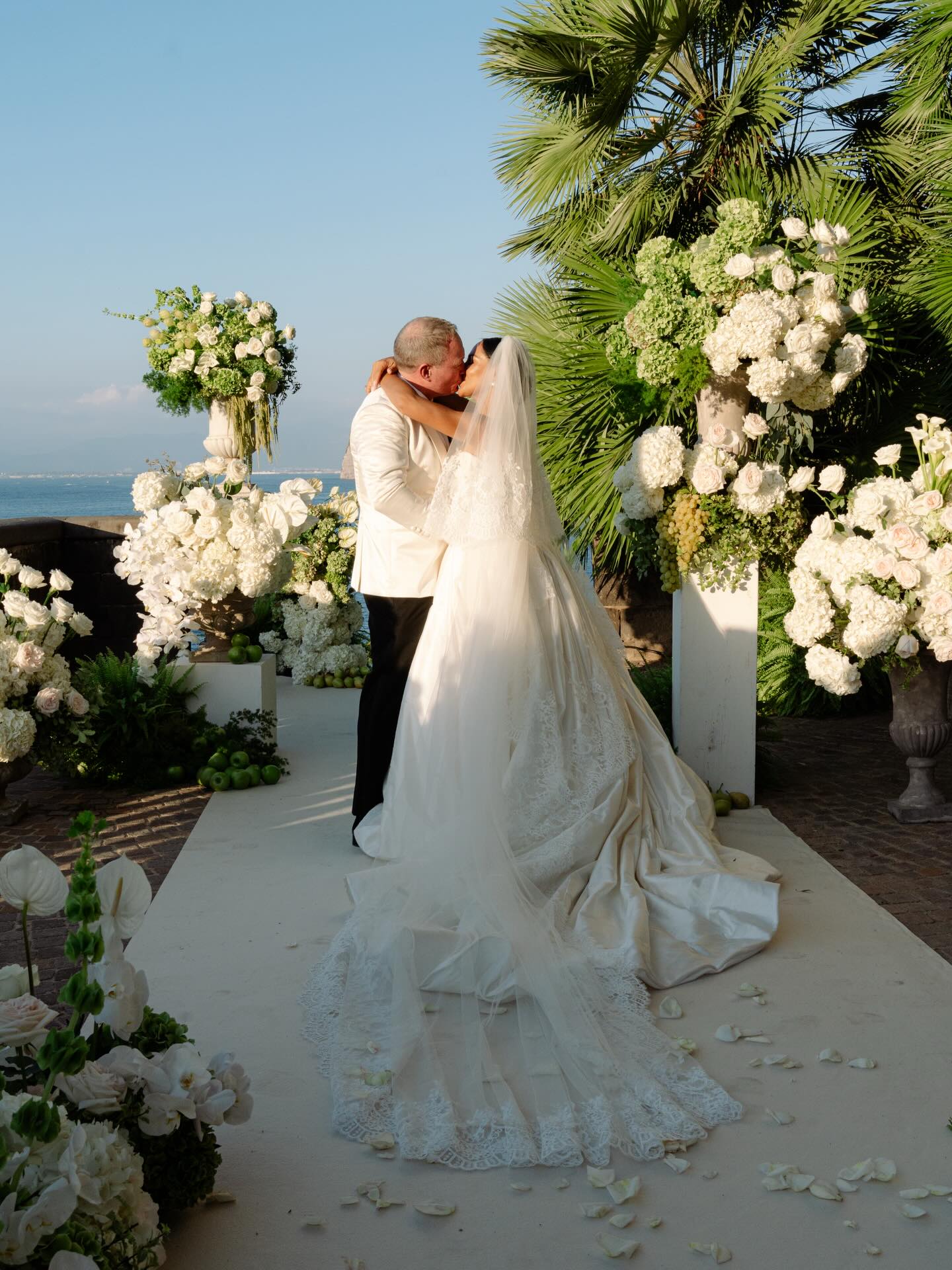 The project is based on a simple palette of green and white shades.
It is inspired by the Mediterranean landscape and its light, using colors that support the atmosphere without being too strong, creating a feeling of elegance and lightness.
The inspiration comes from working closely with the couple, understanding their style and how they imagine their ceremony. This leads to designs where every detail reflects their vision in a natural and coherent way.
There is a careful balance between spontaneity and control, allowing the arrangements to feel natural while still enhancing the setting. The result is a sense of calm, relaxed elegance, and attention to subtle details.
From the choice of colors to the layout of the spaces, everything is designed to guide the experience: from the ceremony to the transitions and the table settings.
The overall style is simple and refined, where everything flows naturally. It reflects the true beauty of the Mediterranean atmosphere: warm, welcoming, full of life, and elegant in its simplicity.
Planning & Design @lindemanweddings
Flowers @alessiominottodesign
Venue @villa_astor
Photographer @angigraphy
Catering @sorrentowedcatering
Dress @leahdagloria
Hair & Makeup @beautylivery
Videographer @mv_lifestyle_films
#floraldesigner
#behindthescenes
#floralwedding
#designerlife
#creativedirection