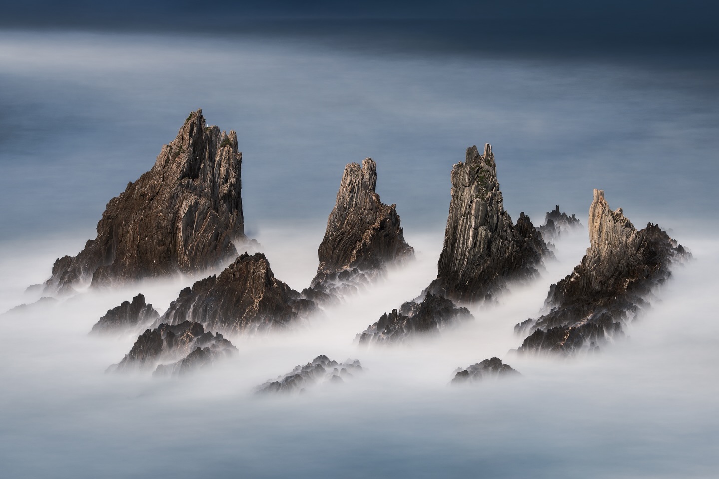 Ancient tides, timeless shapes.
There are places that feel like they don’t belong to our time. This stretch of coast in Asturias is one of them. Jagged rock formations rise from the ocean like remnants of a forgotten world, shaped by forces far older than anything we can truly grasp. With every tide, the scene transforms. Water wraps around the rocks, softening their harshness, only to retreat again and reveal their raw, sculptural presence.
I came back to this place three times during my latest trip. Different tides, different light, different moods, yet always the same quiet intensity. It’s fascinating to witness how something so solid can feel so alive, constantly changing and never repeating itself.
For me, this is what makes photography so special: Returning, observing, and slowly understanding a place beyond the first impression.
Shot on Sony A7 RV + Sigma 70-200mm f/2.8 DG + Maven Filters ND15+ND6 Dark CPL (for extra long exposure times) + framed on Gitzo Systematic Tripod.