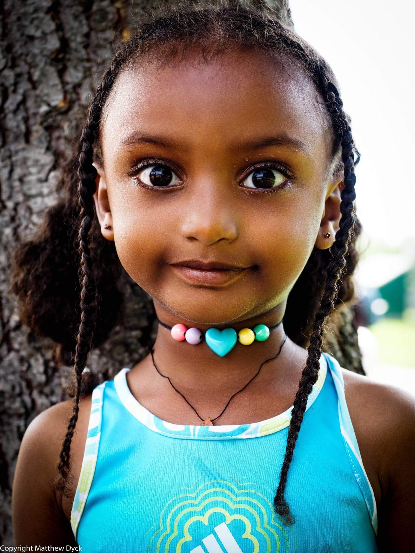 Neon beads, braids, tree bark, sun on skin. Some days the heart doesn’t look like a metaphor at all…it’s right there on a string, glowing just above a small, steady heartbeat. May this child never forget what most adults spend years relearning: you don’t have to earn your brightness; you just have to keep wearing it.
#streetportrait #portraitphotography
#streetphotography #matthewdphoto
