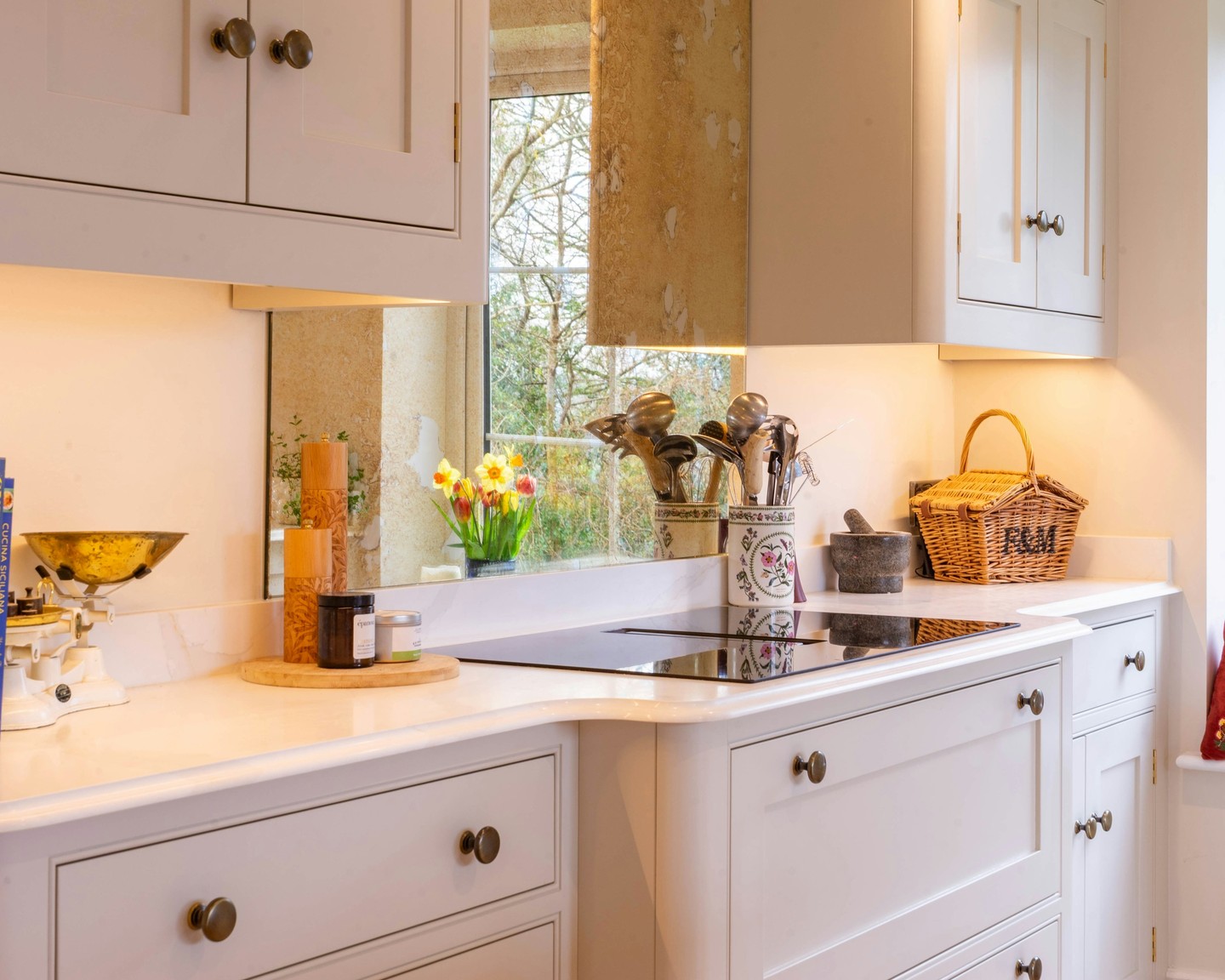 A white kitchen does not have to feel cold. When the lighting is handled well, it brings dimension to every surface, softens the cabinetry, and gives the whole room a warmer, more lived-in character. #BespokeDesign #KitchenInspo #InteriorDesign #ModernLiving