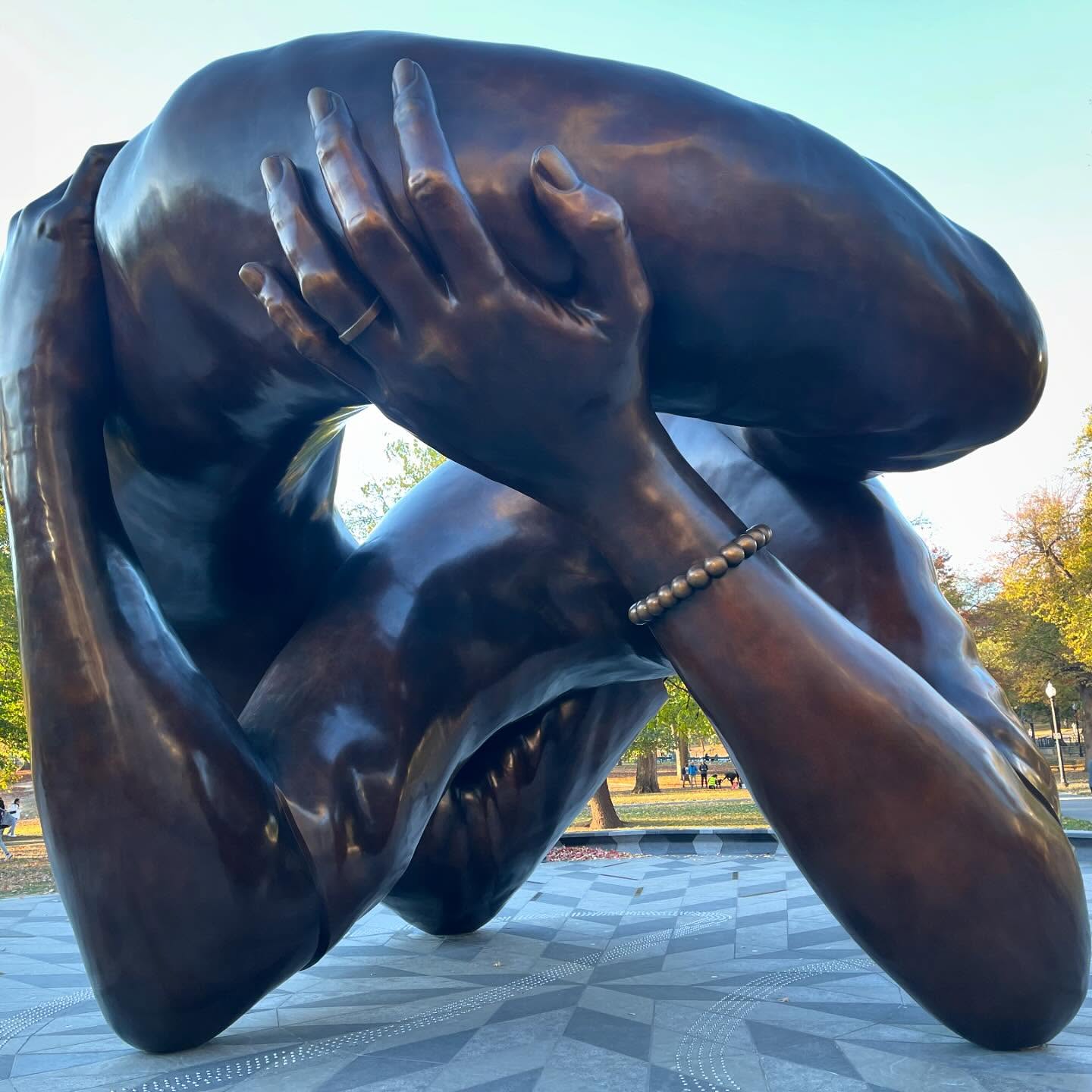 The Embrace statue in Boston, unveiled in January 2023, represents the legacy of Dr. Martin Luther King Jr. and Coretta Scott King, highlighting their commitment to civil rights, love, and justice. Created by artist Hank Willis Thomas, it stands in Boston Common, where Dr. King gave a speech in 1965 during the civil rights movement. The statue’s design is inspired by a photograph taken of Dr. King and Coretta embracing after he won the Nobel Peace Prize in 1964. Instead of full figures, the sculpture captures only their arms, emphasizing the gesture of love, solidarity, and shared purpose between them.
The artwork also serves as a tribute to Boston’s broader civil rights history and the community’s ongoing struggle for equality. Located in the oldest public park in the U.S., it provides a space for reflection on the powerful impact of unity and activism.