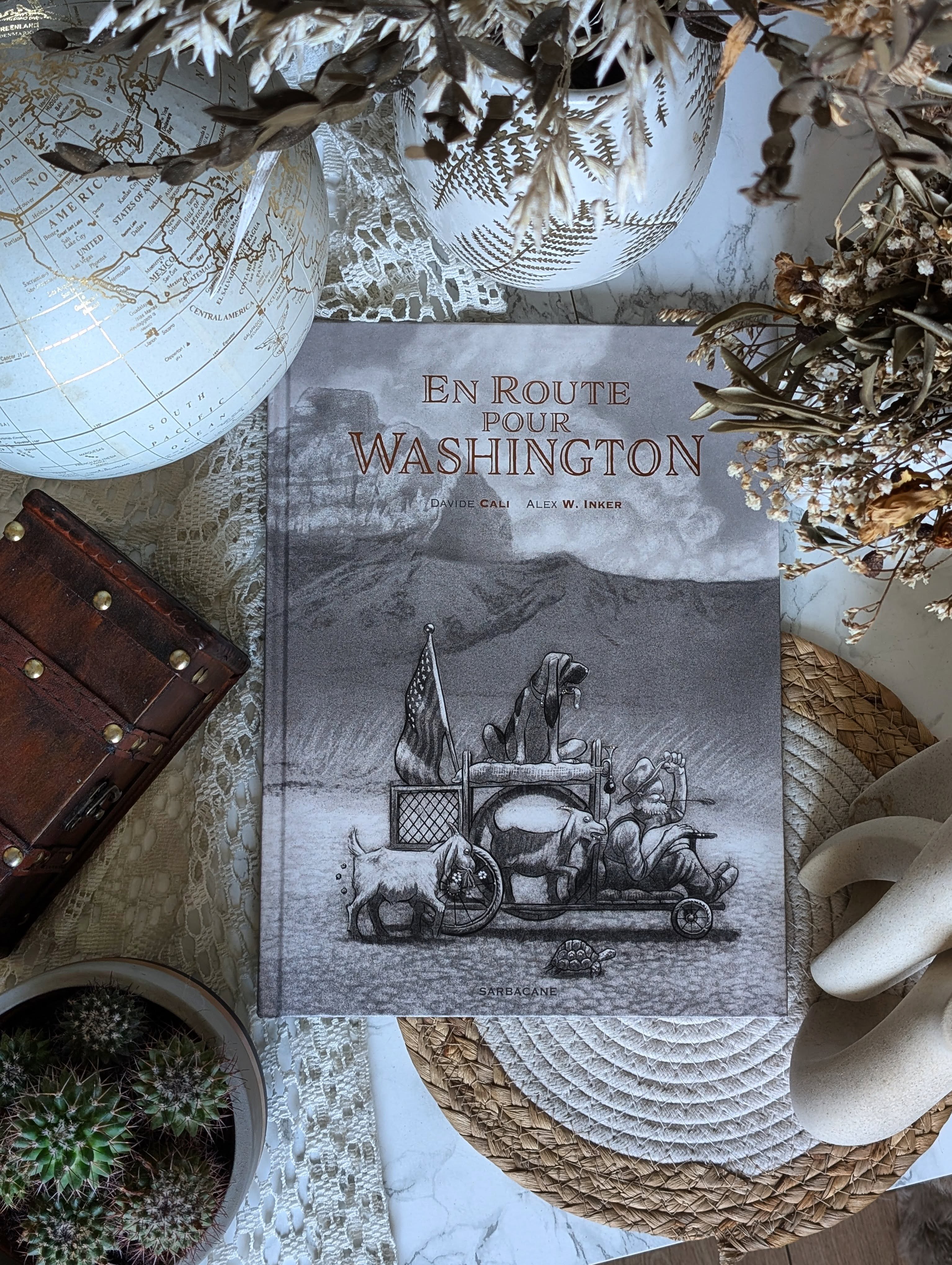 ✨ En route pour Washington - Davide Cali & Alex W. Inker ✨
Partons ensemble pour les États-Unis afin d’entendre la légende de Ray !
Nous sommes en 1933, en pleine sécheresse. Les terres deviennent peu à peu arides, les récoltes meurent, et la poussière engloutit tout ce que les paysans ont cultivé. Dans ce décor, Ray, un humble fermier qui vit dans sa petite maison avec son chien et quelques animaux, décide de ne pas rester les bras croisés alors que son champ de maïs est menacé.
Il se dit une chose toute simple : si le Président savait ce qu’il se passe, il agirait forcément. Et puisqu’il faut bien que quelqu’un lui explique la situation… Ray décide de partir pour Washington, à plus de mille kilomètres de sa maison. Mais cela ne lui fait pas peur, car il a sa super cariole tirée par... une chèvre (je vous laisse la surprise).
C'est ici que commence une véritable épopée, racontée à travers les yeux de trois enfants du coin, fascinés par cet homme ordinaire qui devient à leurs yeux un héros.
Ce que j’ai beaucoup aimé dans cet album, c’est cette manière de mêler espoir et grandeur. Cette aventure est improbable, mais on se laisse emporter parce que le héros, lui, y croit. (Et puis le message est vraiment chouette).
Au fil des pages, l’histoire de Ray devient une légende. Les gens commencent à le reconnaître et c’est là toute la beauté du message : quand on agit, les autres finissent par le remarquer.
Je tiens à souligner le travail d’Alex W. Inker, dont les illustrations sont magnifiques. Ce noir et blanc nuancé apporte une atmosphère singulière qui fonctionne à merveille avec le contexte de l’histoire. L'album est un vrai objet visuel pour le coup, et ça peut s'adresser aux enfants comme aux adultes !
J'ai vraiment passé un bon moment de lecture. C'est parfait pour faire une pause dans votre journée et découvrir cette légende surprenante.
En bref, @editionssarbacane nous rappelle à travers cet album qu'il suffit d’oser pour faire bouger les choses et qu'un individu, aussi modeste soit-il, peut tenter de changer le monde...
Alors, vous allez partir à sa rencontre ?
#Bookstagram #EnRoutePourWashington #DavideCali #AlexWInker #AlbumIllustré
