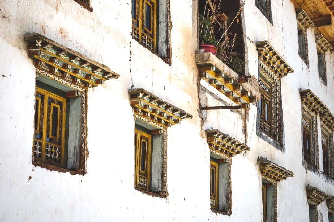 Les maisons tibétaines apparaissent loin des routes tracées pour les regards, là où le tourisme s’efface et où le paysage s'élargit.
Sur ces hauteurs, elles émergent de la terre même dont elles sont faites.
Construites en pisé, façonnées couche après couche, elles portent la mémoire du sol dans leurs murs épais. Des murs puissants, presque aveugles, qui protègent du froid et du vent tout en régulant l'hygrométrie intérieure au fil des saisons.
De l’extérieur, elles semblent massives, ancrées, presque austères.
Et puis on entre.
À l’intérieur, le bois apparaît. Sculpté, coloré, travaillé avec finesse. Les poutres, les encadrements, les autels racontent une autre richesse — plus intime, plus symbolique.
Un monde de détails caché derrière la force brute de la terre.
Des architectures de contraste. Entre rudesse et délicatesse.
_______
Tibetan houses appear far from the roads laid out for the gaze, where tourism fades and the landscape opens wide.
Up on these heights, they rise from the very earth they are made of.
Built in rammed earth, shaped layer by layer, they carry the memory of the ground within their thick walls. Powerful, almost blind walls that protect from cold and wind, while regulating indoor humidity through the seasons.
From the outside, they feel massive, grounded, almost austere.
And then you step inside.
Wood reveals itself — carved, painted, crafted with care. Beams, frames, altars speak of another kind of richness — more intimate, more symbolic.
A world of details hidden behind the raw strength of earth.
Architectures of contrast. Between harshness and delicacy.