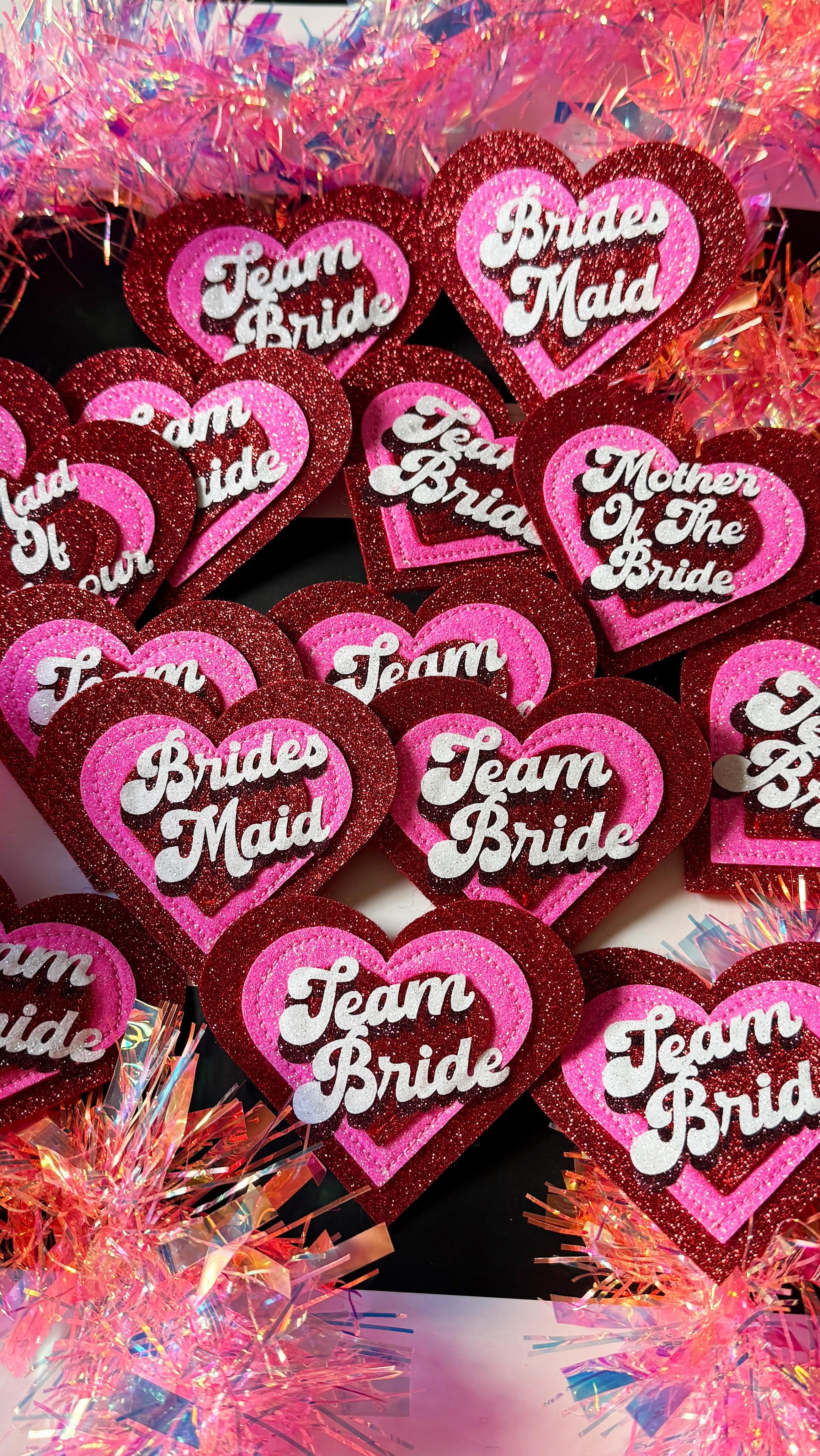Etsy review 😘
Alyson ‘ I ordered a number of badges for my friends hen party, they are excellent quality and exactly what we were looking for. Katie provided excellent customer service when I had a couple of queries and replied to me very promptly. I am over the moon with our order and I know the Bride and the other hens will be too!’ Thank you Alyson 😘
Love making a big set of hen badges! There were a total of sixteen in this order including maid of honour, mother of the bride, team bride x12 and 2x bridesmaids… sounds like it’s going to be fun 🪩
Glitter felt retro style hen party badges in red and pink. Handmade. Team bride. Bride Squad. 2026 bride. Bridal party. Custom wedding. Hen party ideas. Bachelorette. Bridesmaids.
