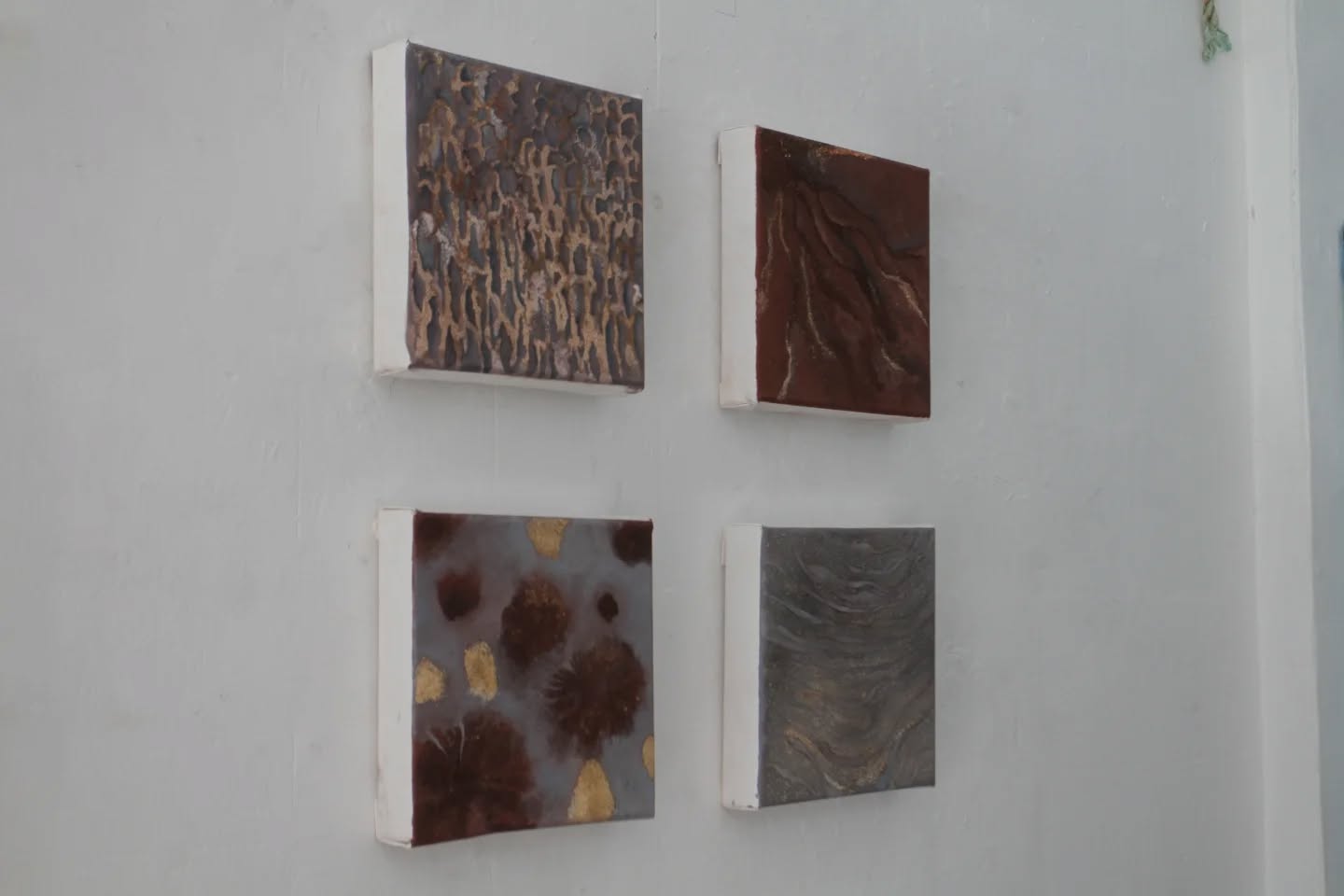 Re-Earth by Orsina Pasargiklian exhibited at Interwoven ( Filet, London)
My practice maps the thresholds where natural and urban landscapes meet, overlap, and fracture.
The architecture-inspired geometric works compare cities to living organisms, suggesting that they evolve over time as if they have an ecosystem of their own. At the same time, the natural palette and damaged surfaces recall earth cracks and reflect on human interference with the environment.
In contrast, my recent earth-based works seek to highlight the resilience and beauty of nature through a scientific lens. Drawing on environmental data and geological research, I explore the evolving character of diverse ecosystems in order to narrate their histories and transformations.
In Re-Earth, this dynamic is examined through a direct engagement with geological matter. I work with magnetic powder, iron oxide, iron filings and crushed rocks such as iron ore, pozzolan, perlite (materials widely extracted for construction and industrial use), that I collected off the road of mining sites. Through oxidation and the material interaction with paint, the surfaces develop textures that emulate erosion, sedimentation, and weathering in an art imitates nature approach.
The installation centres on a large painting in which an architectural structure gradually disintegrates back into its geological origins. The geometric form appears to dissolve into strata, proposing a reversal of extraction and a symbolic return of material to the earth. Accompanying this work are four smaller paintings representing geological processes that unfold independently of human control: wind weathering, hydrolysis, volcanism, and biological weathering. Displayed beside them are the rocks in their raw state.
My interest in geology parallels my interest in architecture: while both narrate temporal change, architecture mirrors accelerated human development, geology embodies deep time and continuous transformation. Re-Earth reflects on the tension between natural and artificial, envisioning a future where nature reclaims its place, not as resource, but as the primary character.
Curated by @joana_alarcao_art @insightsofanecoartist