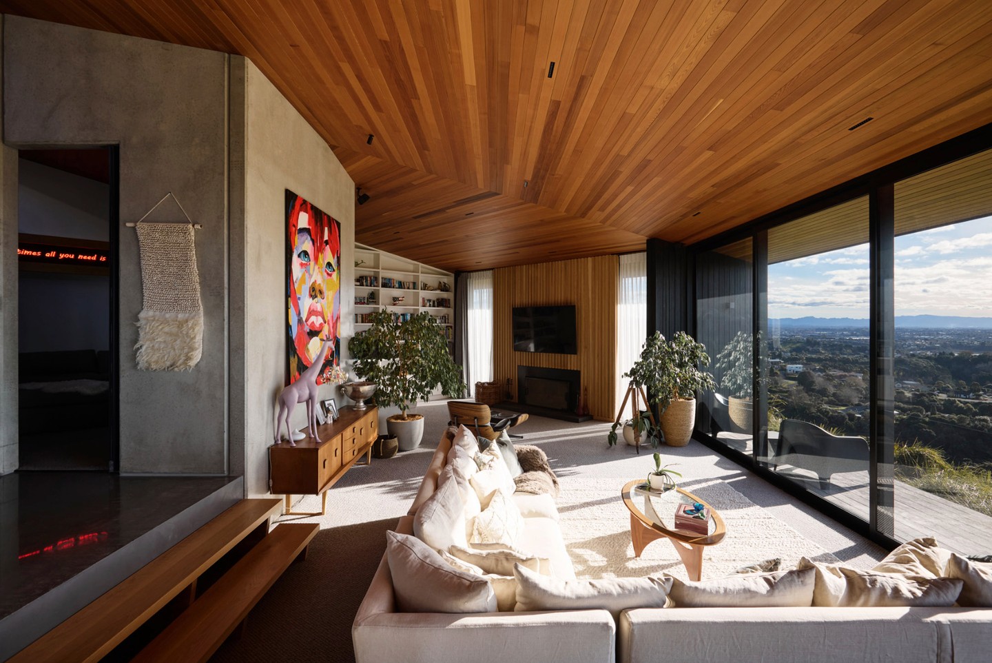 The living wing unfolds toward expansive views — an open plan kitchen, dining and sunken lounge all working together as one connected space. Anchored by concrete elements and softened through subtle level changes, each area feels defined yet effortlessly linked.
Overhead, a striking hexagonal roofline draws the eye upward, lined in Herman Pacific Cedar. Handcrafted over weeks, each piece has been carefully placed to create a sense of rhythm and precision, while blade walls both shape the volume and provide shelter from the elements.
In contrast, the cinema room offers a more enclosed experience — wrapped in concrete tilt panels, creating a snug space to take in a movie.
#CalleyHomes #InteriorDesignNZ #OpenPlanLiving #ArchitecturalInteriors #DesignAndBuild
