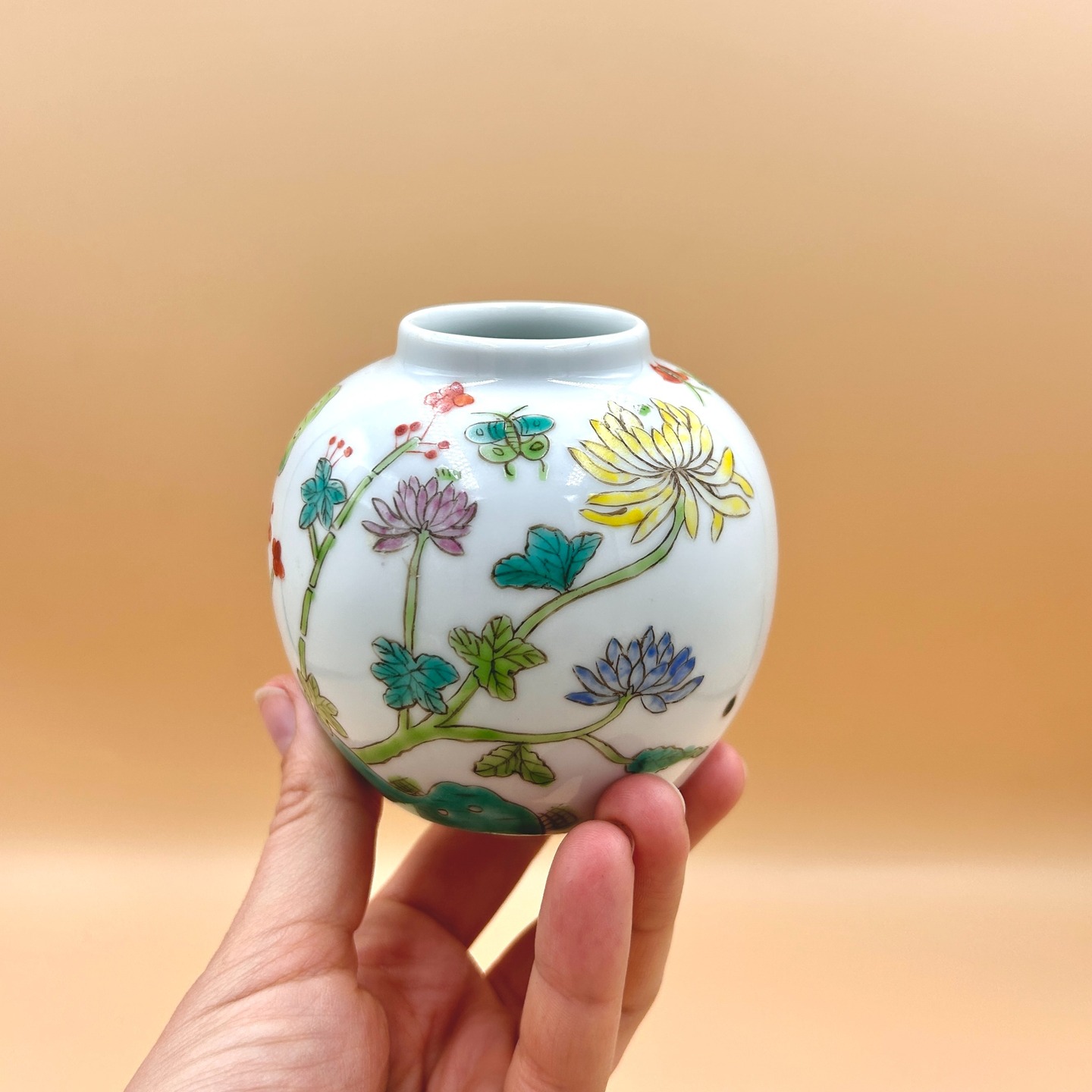 ❌ SPRZEDANY | Mikro wazonik famille verte, Chiny, lata 80. XX w.
Porcelanowy wazonik z solidnej porcelany, ozdobiony rzadkim motywem famille verte.
Klasyczne *famille verte* to styl dekoracji porcelany rozwinięty w Chinach w okresie dynastii Qing, szczególnie za panowania Kangxi (1662–1722). Charakteryzuje się paletą emalii naszkliwnych z dominacją zieleni, uzupełnianą przez żółcie, błękity, czerń i sporadycznie czerwień żelazową. Dekoracje obejmują sceny figuralne, pejzaże oraz motywy roślinne i symboliczne, często o wysokim poziomie szczegółowości i narracyjności.
Motyw kwiatów i motyli w sztuce chińskiej symbolizuje radość życia, miłość oraz harmonię natury, często odnosząc się do romantycznej relacji i ulotnego piękna. Zestawienie to ma także wymiar życzeniowy, wyrażając szczęście, pomyślność i spełnienie w życiu osobistym.
Synagtura apokryficzna okresu Republiki.
Wys. 10 cm
65 PLN + 15 PLN