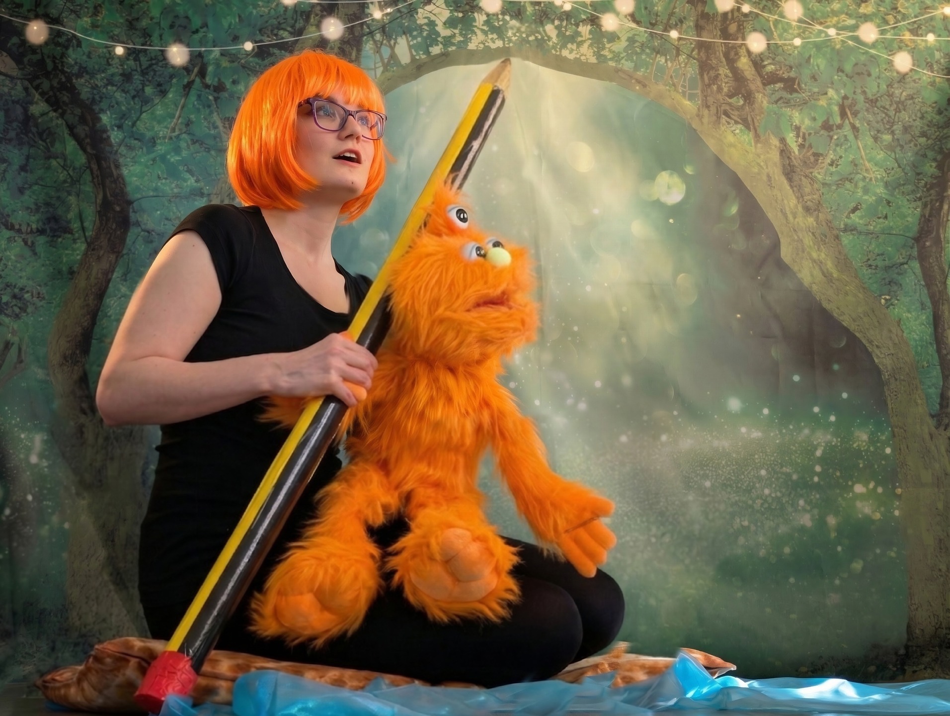 THE TOUR HAS STARTED!
Today our cast and crew were in Leicester performing for children and adults who have been attending @vistaleicester. Here are a few quotes from audience members:
"The audience interaction was really good. I enjoyed that they came right up to us with the puppets. I also really liked the touch tour in the middle; this gave us the chance to feel the props and help understand the story more."
"I loved the blue Play-Doh and watching the fun show. There were lots of things to feel and touch."
"I really enjoyed watching and singing along to the songs and the music. I enjoyed Beastie going on her little adventure. The colourful bouncy ball was great to play with."
Photo 1:
A performer with vibrant, bobbed orange hair and purple glasses sits against an enchanted forest backdrop. She is holding a giant, oversized yellow pencil and has a friendly, three-eyed orange furry monster puppet resting on her lap. The scene is lit with soft, magical bokeh lights.
Photo 2:
Against a magical woodland background, a performer with bright purple hair interacts with a tall, fuzzy purple puppet. The puppet features three large eyes and a prominent blue nose. The performer’s expression is one of wonder, as if caught in mid-conversation with the creature.
Photo 3:
A performer with striking blue hair and glasses stands in front of a forest scene, arms outstretched in a dynamic pose. She is surrounded by floating, colourful silk scarves in shades of red, yellow, and purple, creating a sense of movement and magic.
Photo 4:
A warm and smiling woman holds the "Bedtime Beastie" book, which features a vintage-style map and ornate gold lettering on the cover. The lighting is soft and focused, highlighting the book that serves as the heart of the story.
Photo 5:
Wearing playful, heart-shaped blue sunglasses and a black hood, a performer reaches upwards toward a large, colourful bouncy ball. The ball is a gradient of green, yellow, and blue, appearing to float against the backdrop of a shimmering, magical forest.
#theatre #inclusion #performance #makingadifference #actcessible