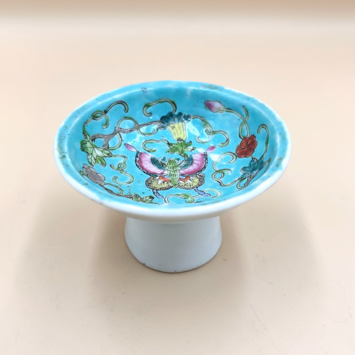 🟢 DOSTĘPNY | Rzadki talerzyk na nóżce, Chiny, dynastia Qing, koniec XIX w.
Niewielka czarka na wysokiej stopie (typ stem cup / 高足杯), wykonana z porcelany i dekorowana w technice emalii naszkliwnych na turkusowym tle (famille verte / famille rose w wariancie na turkusie, tzw. „turquoise ground”), inspirowanej estetyką wyrobów z okresu Qing (szczególnie Kangxi/Yongzheng).
Naczynie wykonane w duchu historyzującym, naśladującym wcześniejsze wzorce.
10 cm x 6 cm
180 PLN + 20 PLN koszt wysyłki