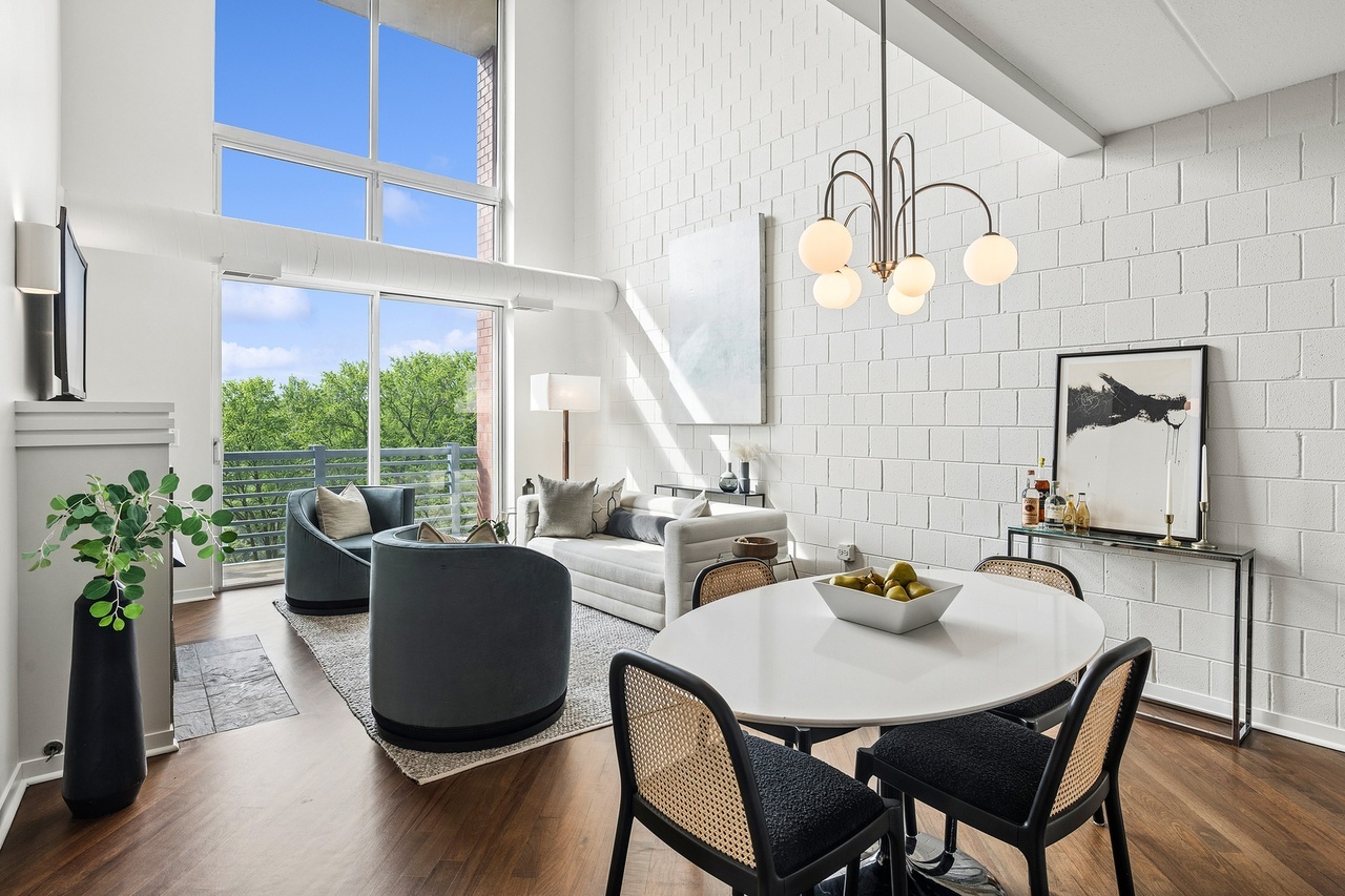 Obsessed with the soaring ceilings, subtle pop-of-color kitchen cabinets, and dining light fixture! It all works together to show a chic and unique space! #chicago #chicagorealestate #havenhomestager #chicagohomestaging #stagingworks #stagingsells #staging #homestaging