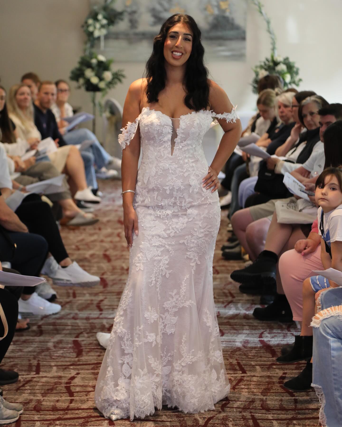 Palmer by Casablanca radiates feminine romance. Detachable off-the-shoulder sleeves connect to a strapless plunging neckline for a wedding day style as vibrant as it is versatile. Stretch lining and Chantilly lace complement your natural curves in this fit-and-flare gown with 60” train. Rich in floral appliques, delicate beading, and sequins, Palmer exudes subtle shimmer with every step.
@casablancaflagship - Style 2491 ‘Palmer’
#fitandflare #laceweddingdress #yateley #bridal #bride2026