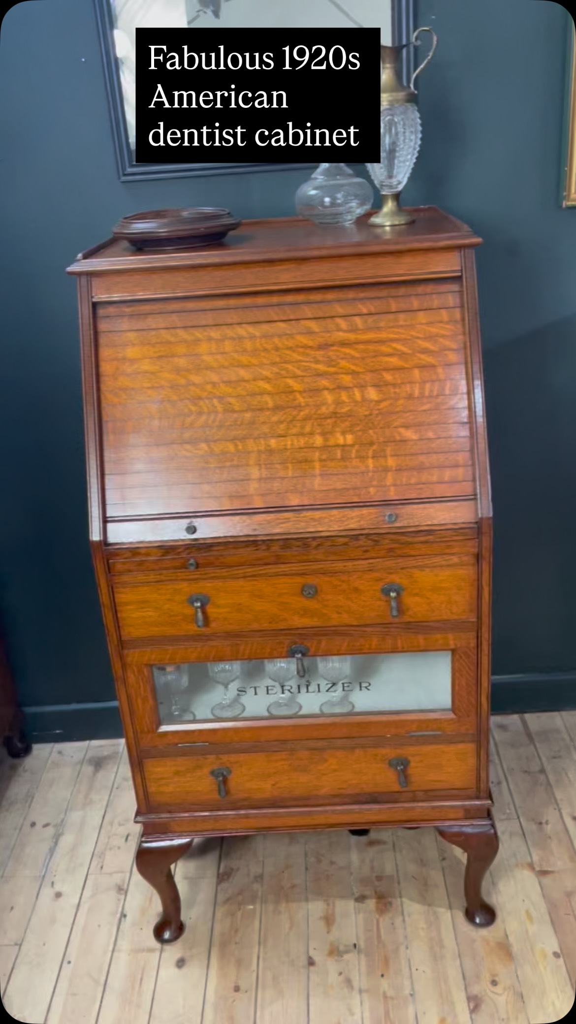 A rare find, this American dentist/ medical cabinet dates from 1920s. Beautifully made from solid oak it has top tambour unit that reveals pigeon holes and drop down tray ( originally designed to hold medical instruments)
It has a pull-out writing desktop, 2 drawers and a drop down ‘ sterilizing’ cupboard with glazed front. It is a compact piece that is multifunctional and would work well as a desk for holding paperwork and other equipment.
It is in fabulous condition with gorgeous finish to the wood and really is quite unique. It measures W63cm H119cm D58cm £395
PS Who spotted the nosy cat that was hiding underneath? 🐈⬛