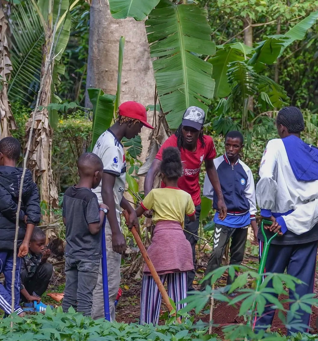 It’s been inspiring to see the Wajukuu Arts group intentionally use the school holidays to engage young people in practical, hands-on learning.
Just two weeks after establishing a new shamba together in an urban location, the space is already evolving. Through an intensive Training of Trainers (ToT) approach, youth leaders are guiding students through core gardening fundamentals now translating knowledge into action as they expand the design and build out additional beds. With the ongoing rains, over 20 crop varieties have already been planted, supporting the group’s goal of strengthening and amplifying their weekly feeding programme.
Wajukuu is a youth-led initiative based in Mukuru slum, one of Nairobi’s informal settlements, where communities often navigate limited access to basic services, green space, and fresh, nutritious food. Despite these constraints, there is a strong culture of creativity, collaboration, and resilience, especially within this group.
Investing in skills like regenerative gardening and land stewardship is pivotal. It not only supports immediate food production but also builds long-term capacity, equipping young people with practical tools, a sense of agency, and pathways toward greater food security and community wellbeing.
