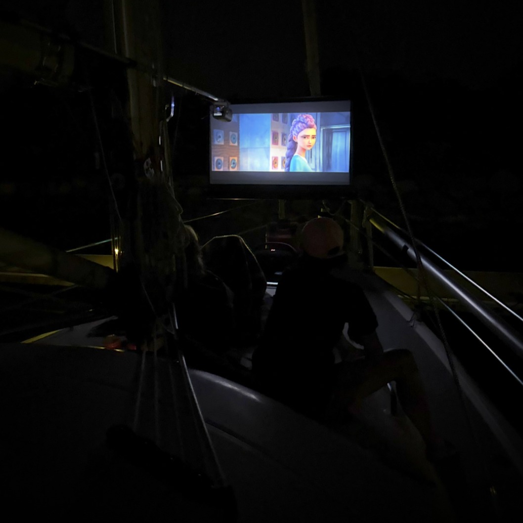 Movie Night on the Bow of Hold Fast (Marina Edition)
Watching KPop Demon Hunters for the 9th time. This time with friends… so it’s not weird or anything. 😂😂😂
What can I say… I love it.
There’s something about sitting on the bow, tied up in the marina, projector humming like a loyal diesel cousin, turning the front of the boat into a floating drive-in theater for wayward sailors and whoever wanders by with a drink and zero plans.
It’s ridiculous. It’s unnecessary. It’s absolutely perfect.
Pro tip: If you own a sailboat… buy a projector. Trust me—this is peak civilization.