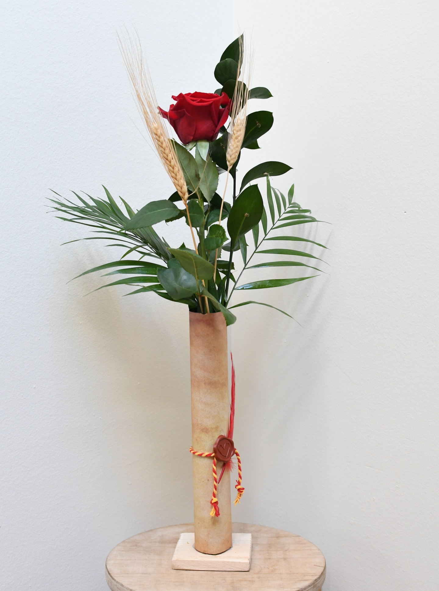 ROSA PERGAMÍ
La rosa pergamí és la gran novetat d’aquest any amb un format diferent.
Composició del producte:
• Rosa Freedom tallada
• Proveta amb base de fusta
• Paper tipus pergamí (papir)
• Ploma decorativa
• Segell en forma de cor
• Llaçada amb cinta de la senyera
• Verds: ruscus i chicos
• 2 espigues seques
Disponible a la web.